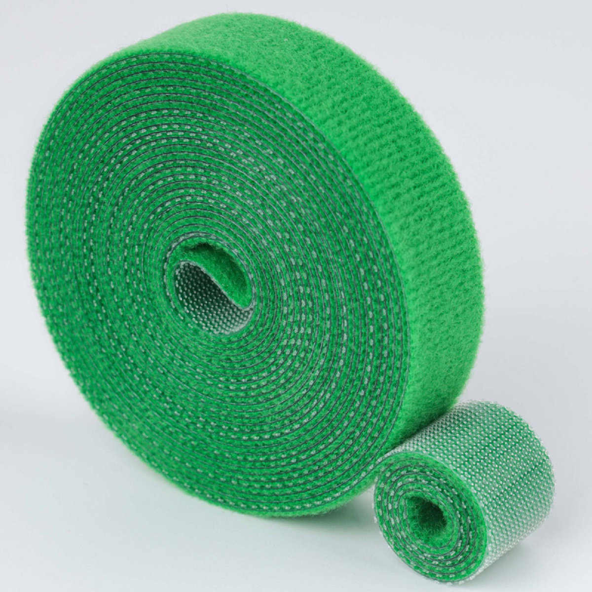 Due rotoli di velcro verdi su sfondo bianco.