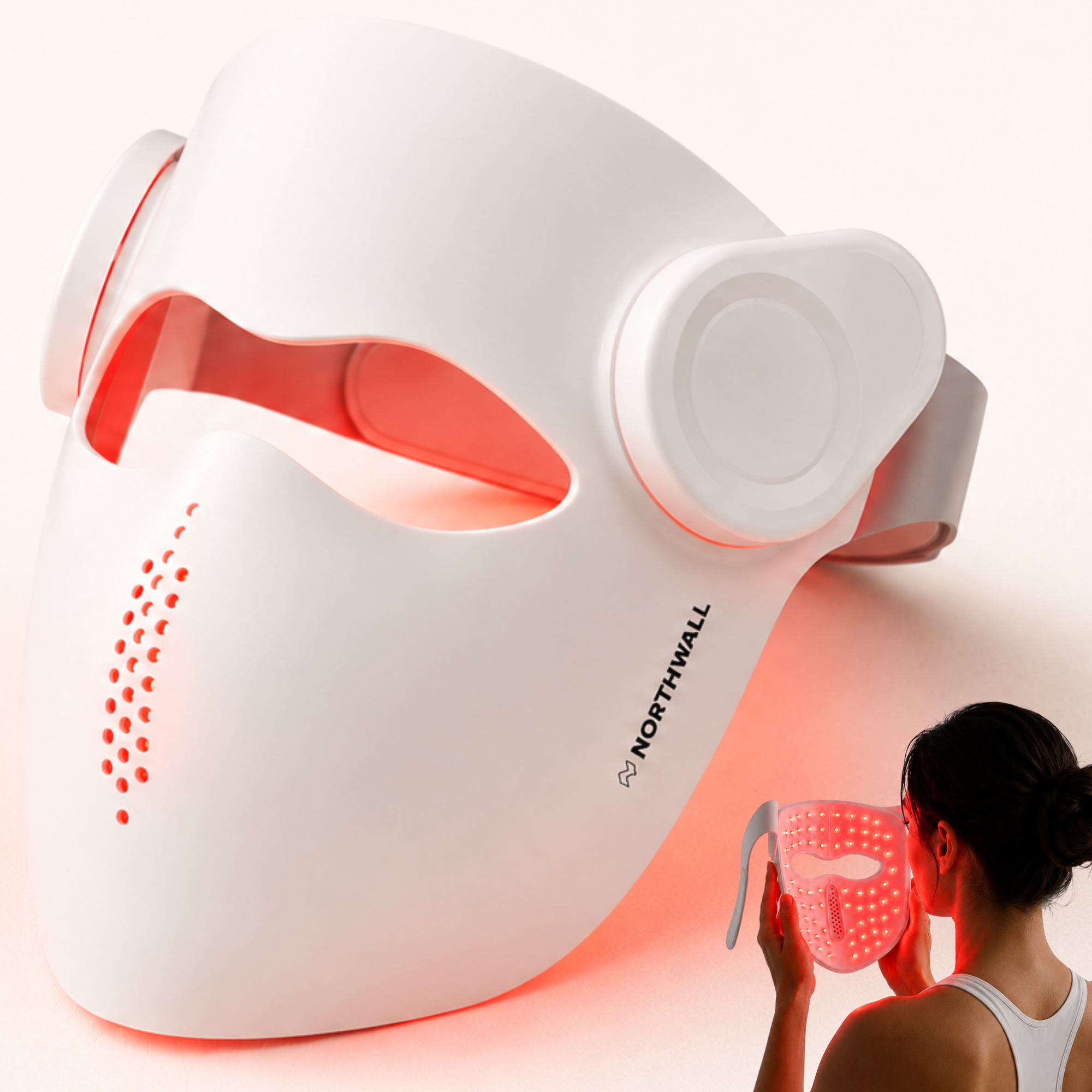 Een wit LED-gezichtsmasker met rode lampjes, vastgehouden door een vrouw.