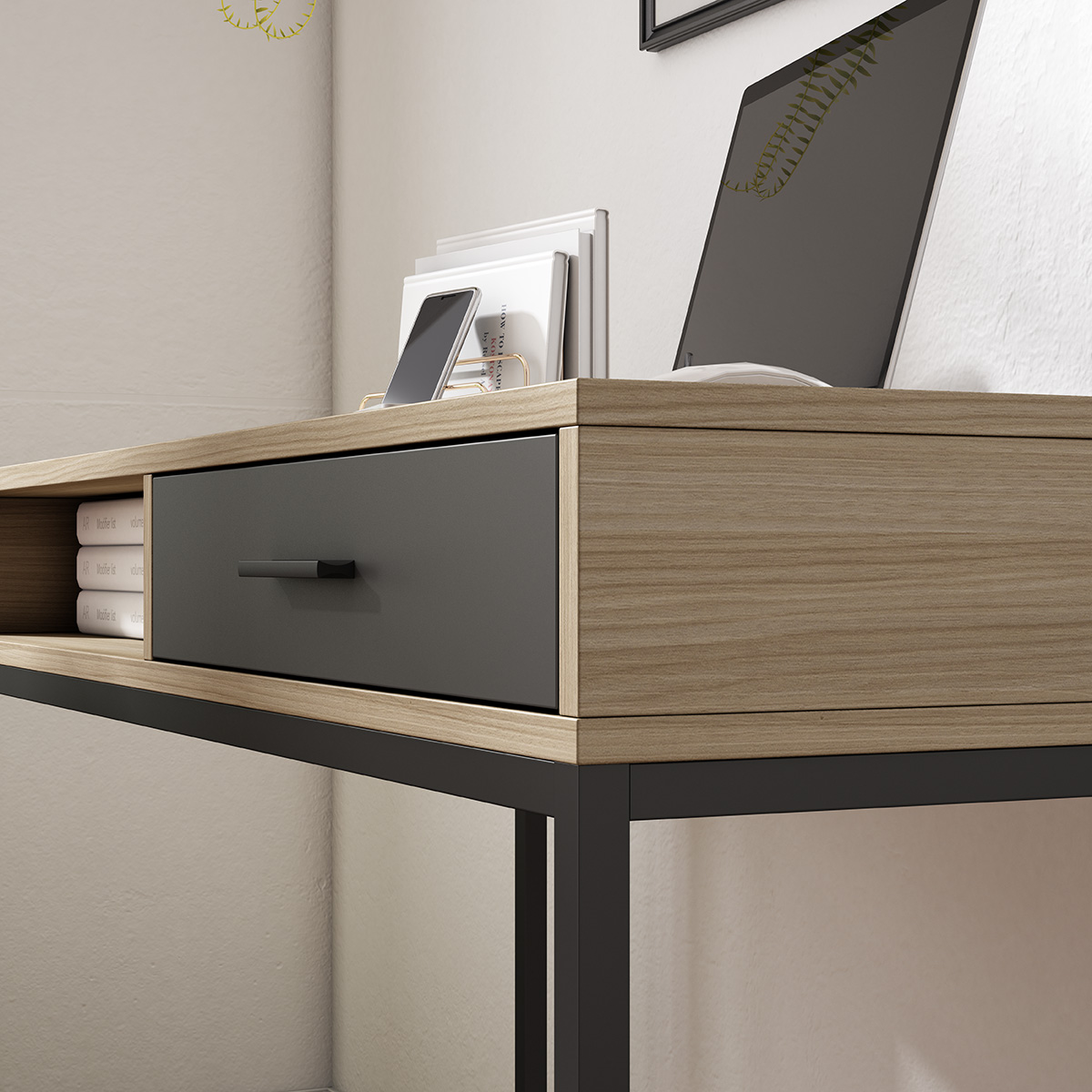 Un escritorio moderno con acabado de veta de madera y un cajón gris oscuro. Hay un portátil y libros encima.