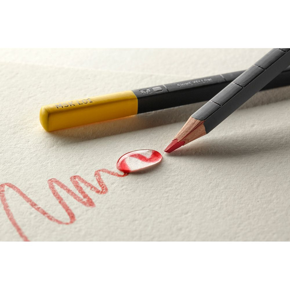 Una matita rossa e una gialla su carta. Un segno rosso è disegnato sulla carta.