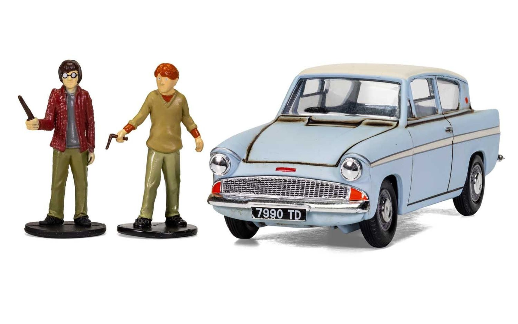 Dwie figurki, Harry Potter i Ron Weasley, obok jasnoniebieskiego samochodu.