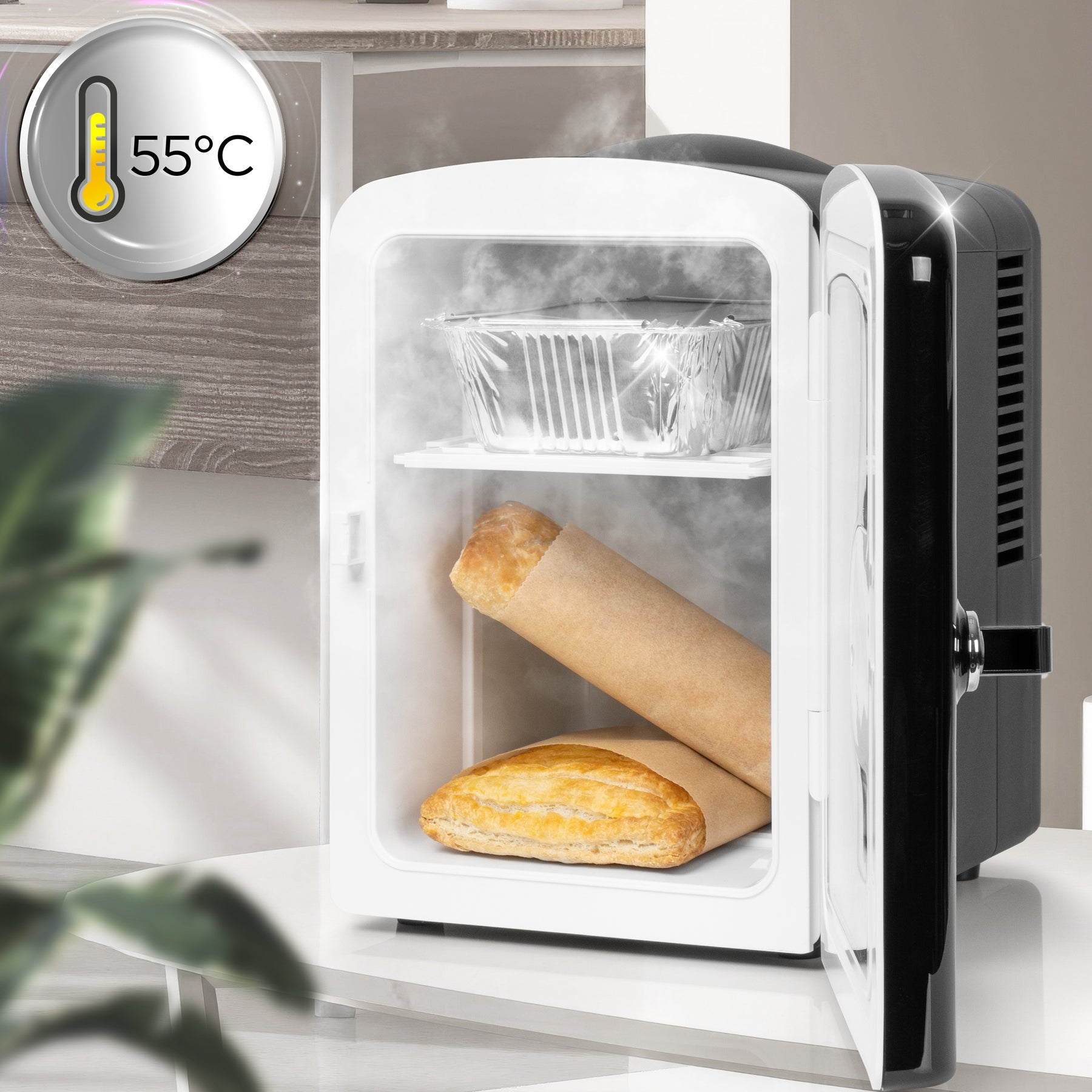 Ein kleiner weißer Kühlschrank mit offener Tür, der zwei Brote und eine Aluminiumschale enthält.