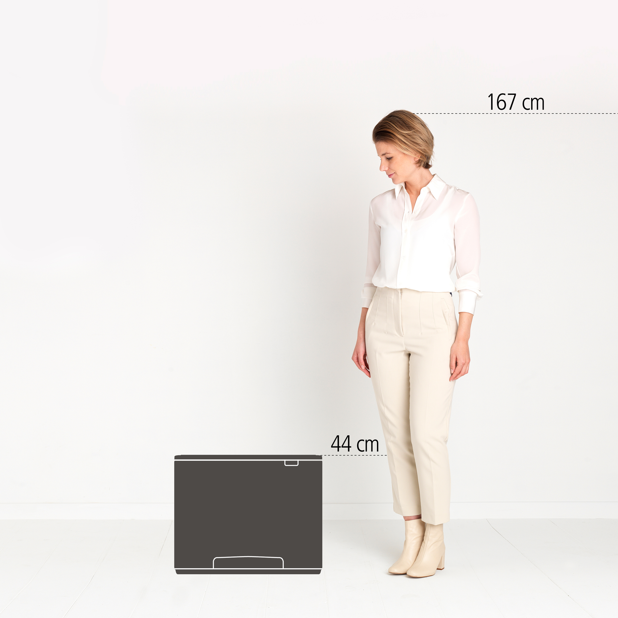 Eine Frau steht neben einem dunklen Objekt mit der Aufschrift 44 cm. 167 cm.