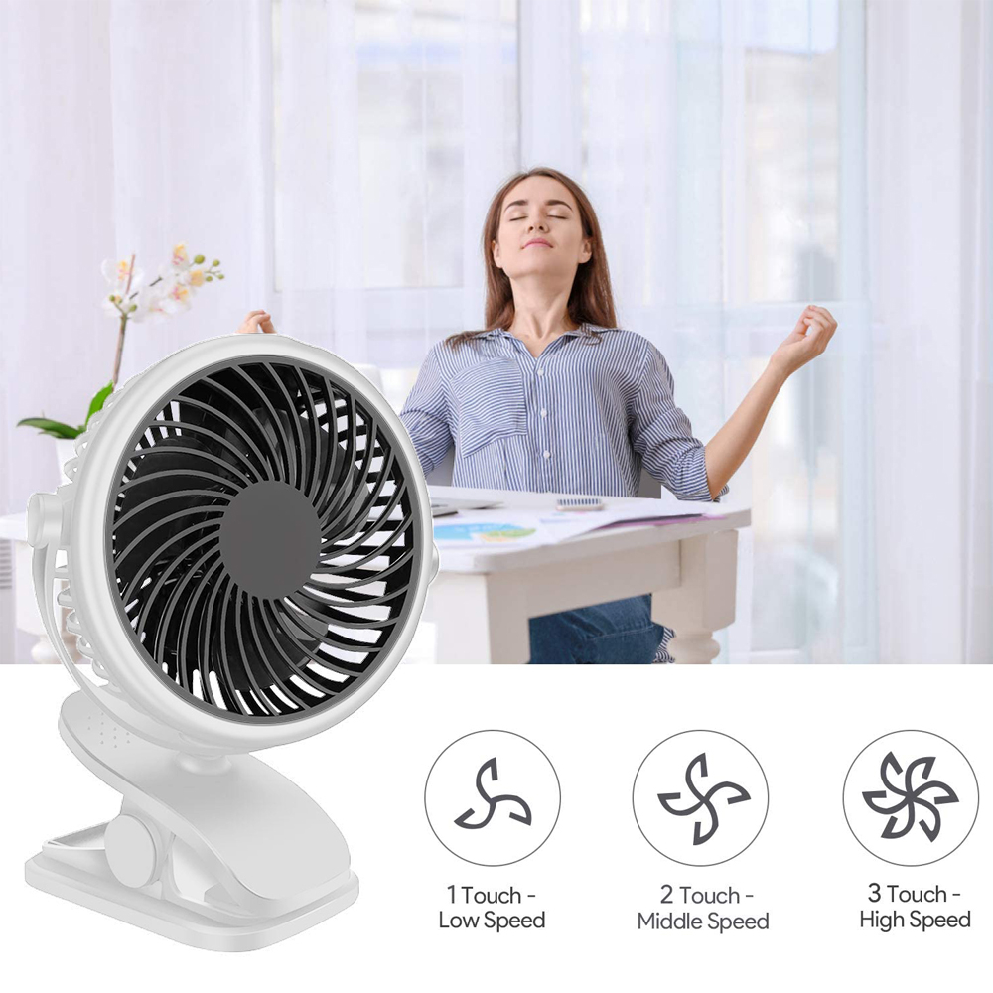 Ein weißer Clip-Ventilator steht auf einem Schreibtisch. Eine Frau sitzt im Hintergrund.