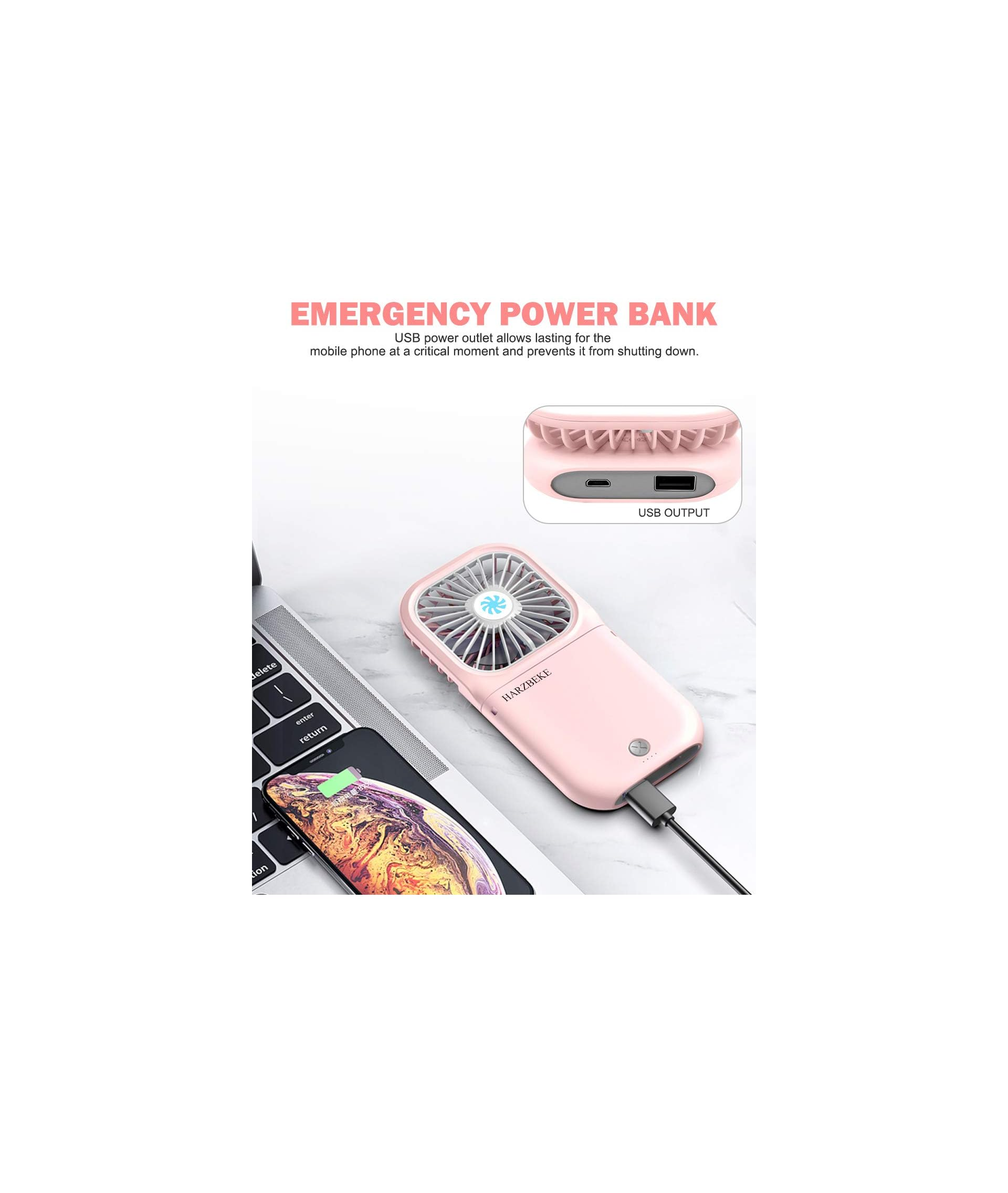 Ein rosa Handventilator mit USB-Ausgang liegt auf einer Tastatur neben einem aufgeladenen Smartphone.
