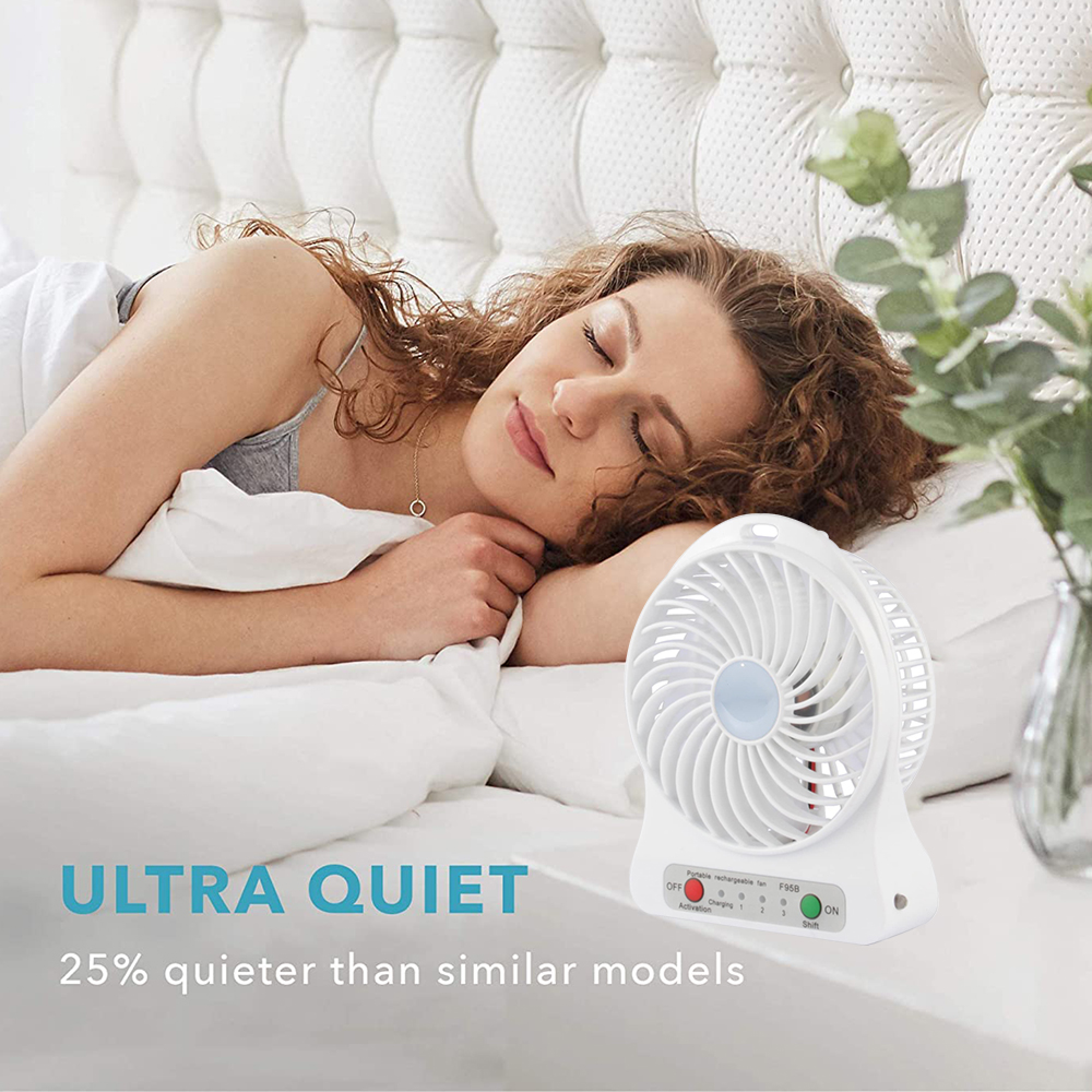 Eine Frau schläft im Bett neben einem weißen Ventilator.