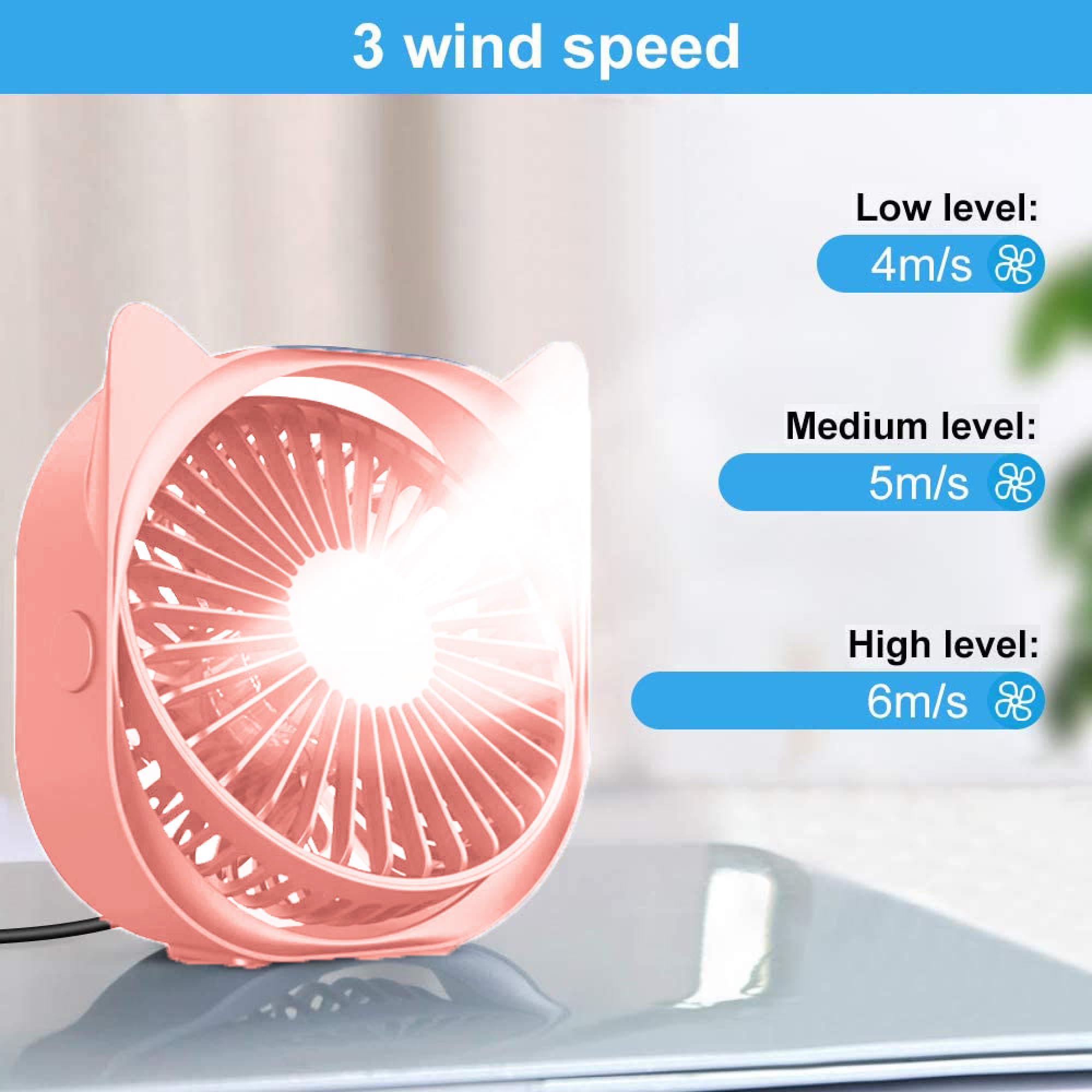 Ein korallenfarbener Mini-Ventilator mit Katzenohren, der auf einem Tisch steht. Informationen zu 3 Windgeschwindigkeiten.