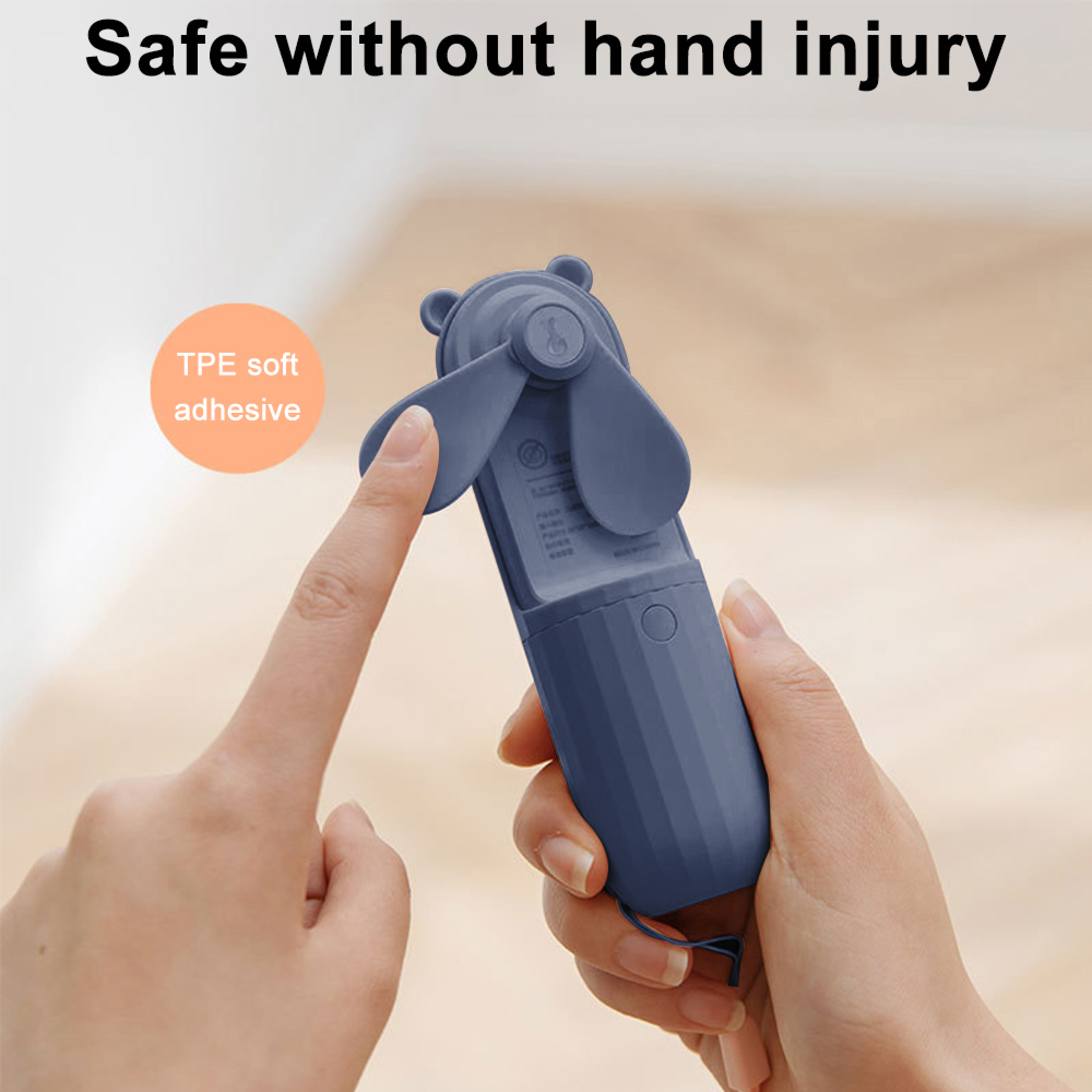 Eine Hand hält einen blauen Mini-Ventilator mit Bärenohren. Ein Finger berührt die Flügel.