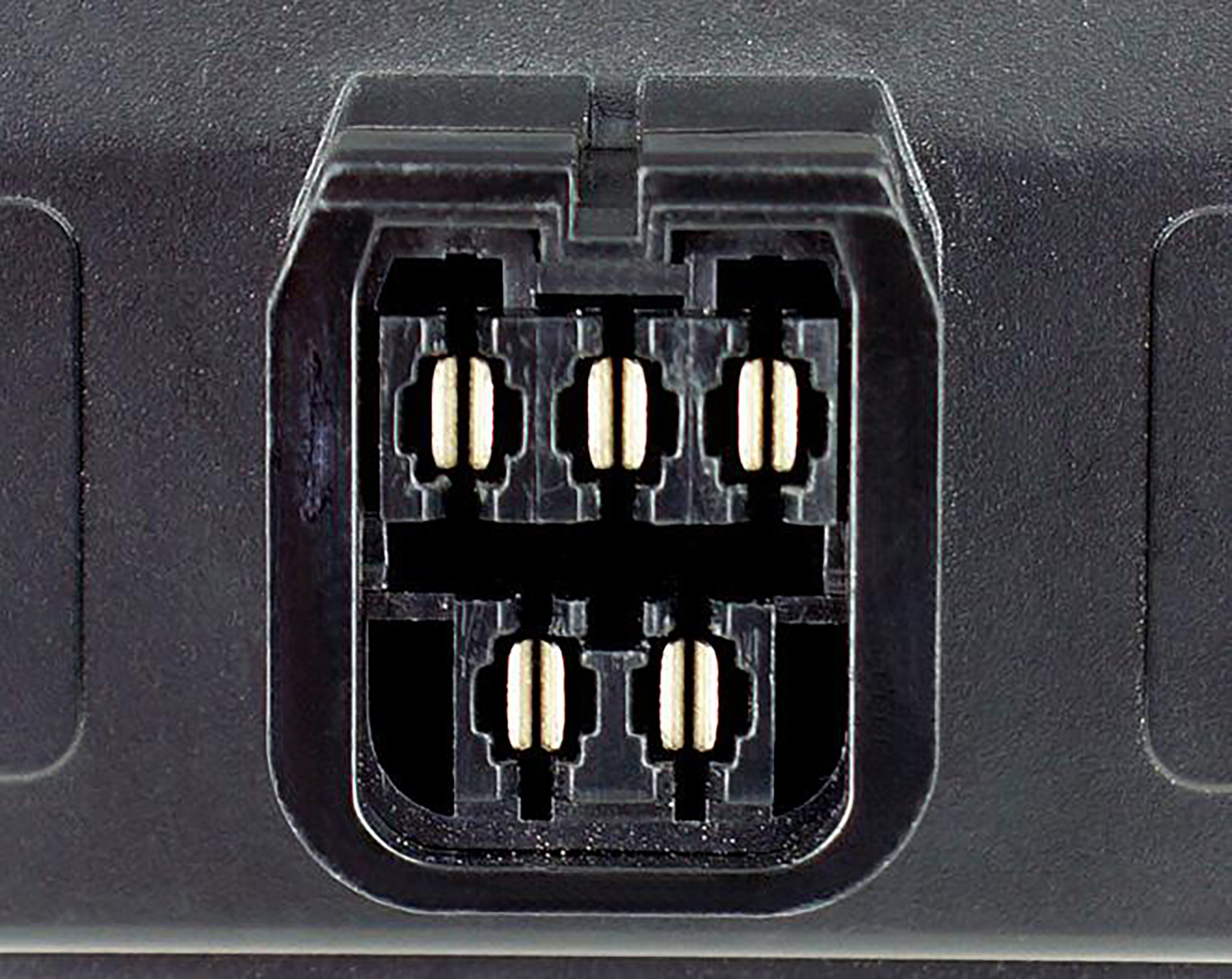 Nahaufnahme eines schwarzen Steckverbinders mit sechs Kontakten und hellen Metallstiften.