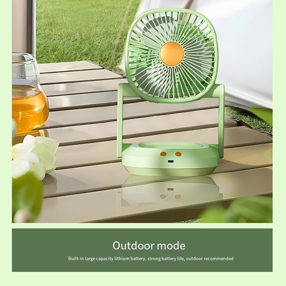 Ein kleiner grüner Ventilator steht auf einem Holztisch. Draußen Gras und Zelt im Hintergrund.