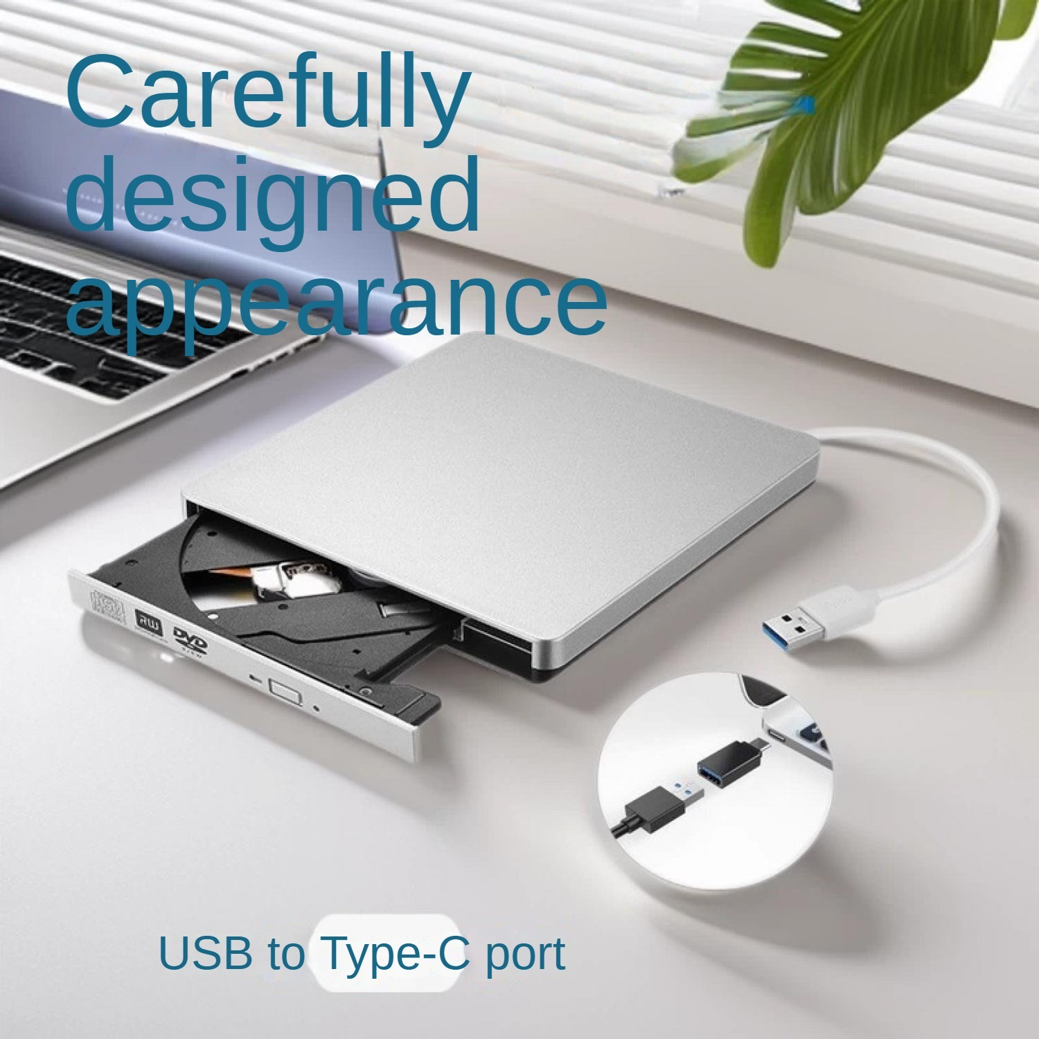 Externes silbernes CD/DVD-Laufwerk an Laptop angeschlossen. USB-C-Adapter gezeigt.