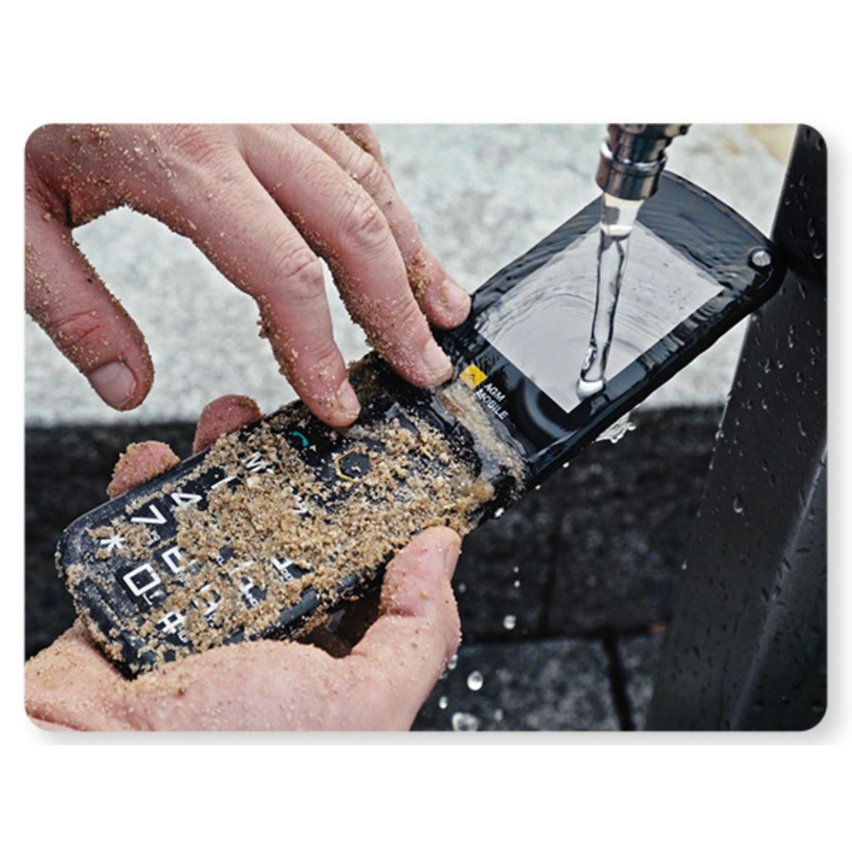 Hände reinigen ein sandiges Handy unter fließendem Wasser.