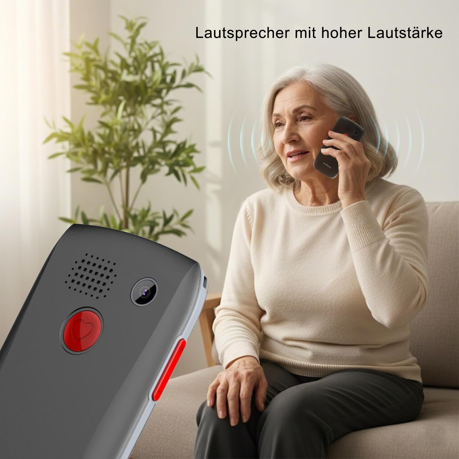 Ältere Frau telefoniert mit einem großen, dunkelgrauen Telefon mit rotem Knopf.