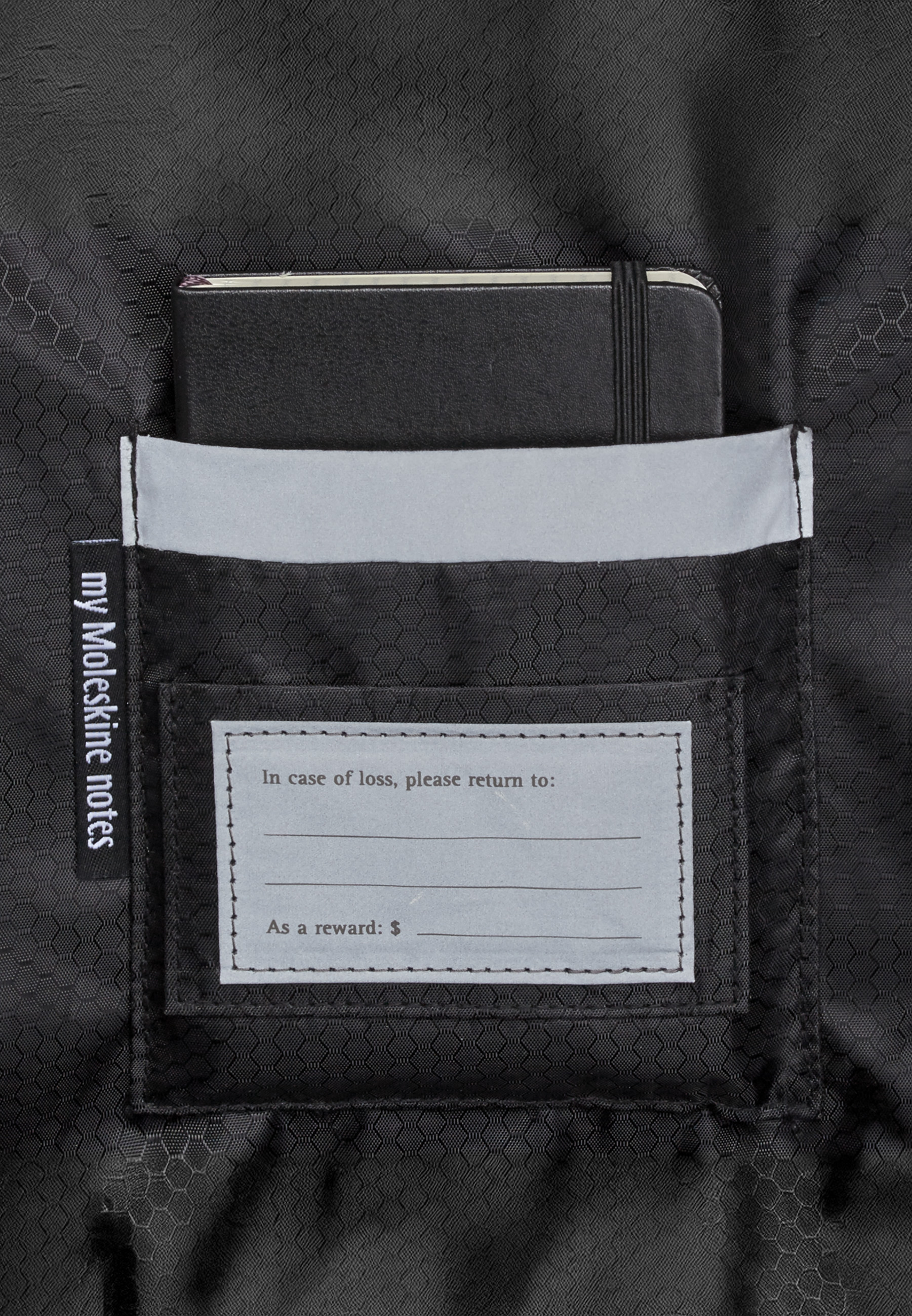 Taccuino nero in una tasca con etichetta indirizzo e tag "my Moleskine notes".