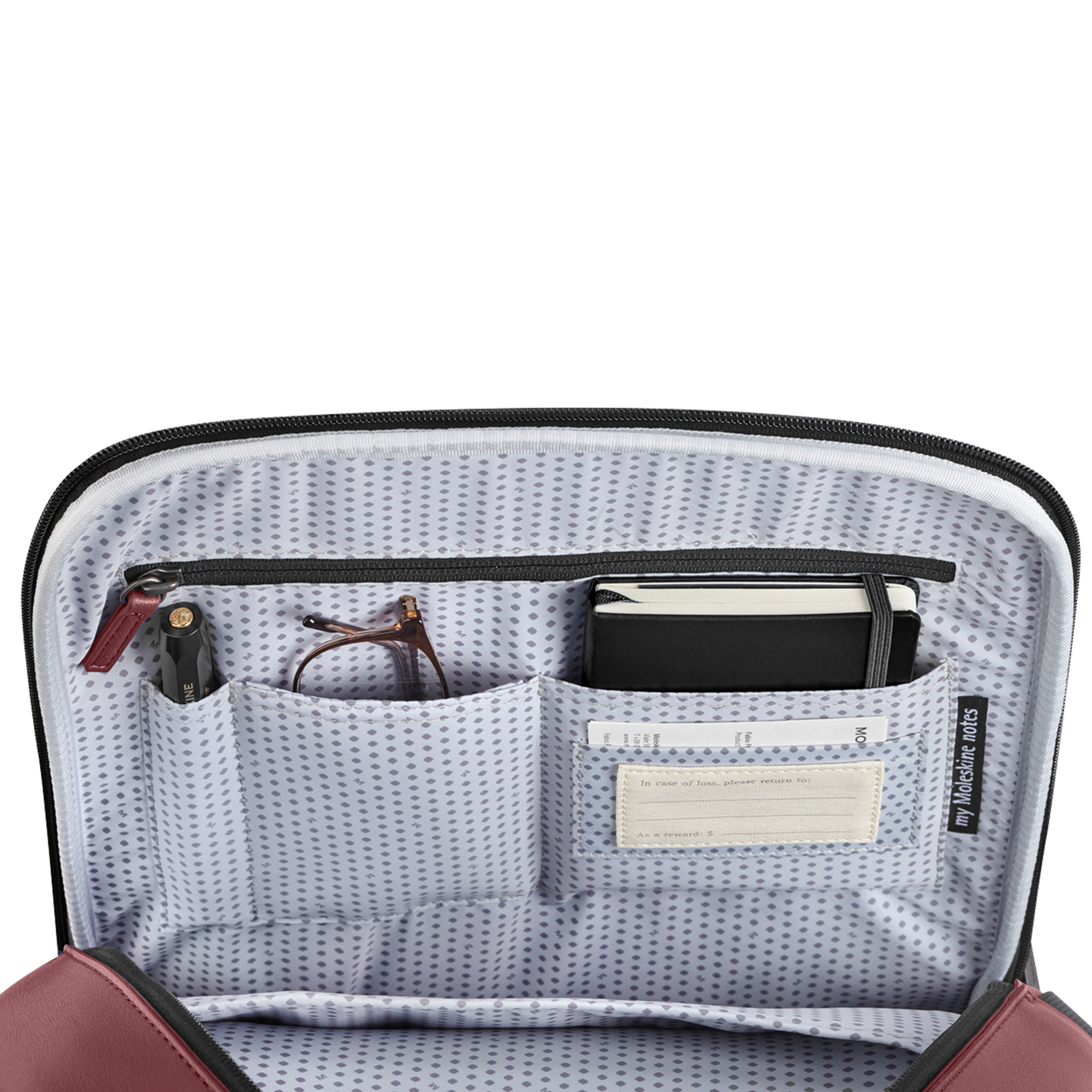Interno di una borsa con penna, occhiali e taccuino.