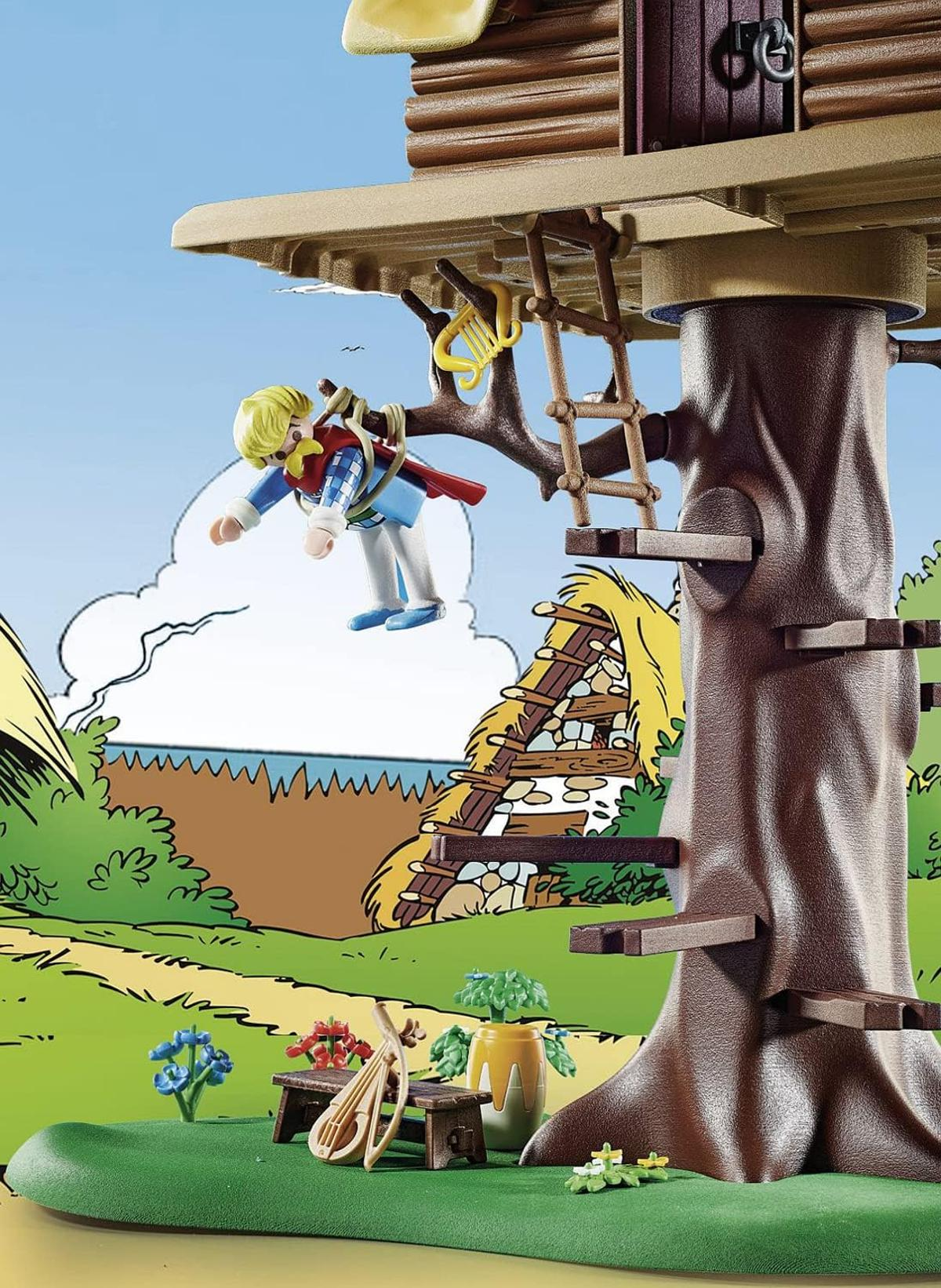 Eine Spielzeugfigur hängt an einem Ast in der Nähe eines Baumhauses mit Leiter.