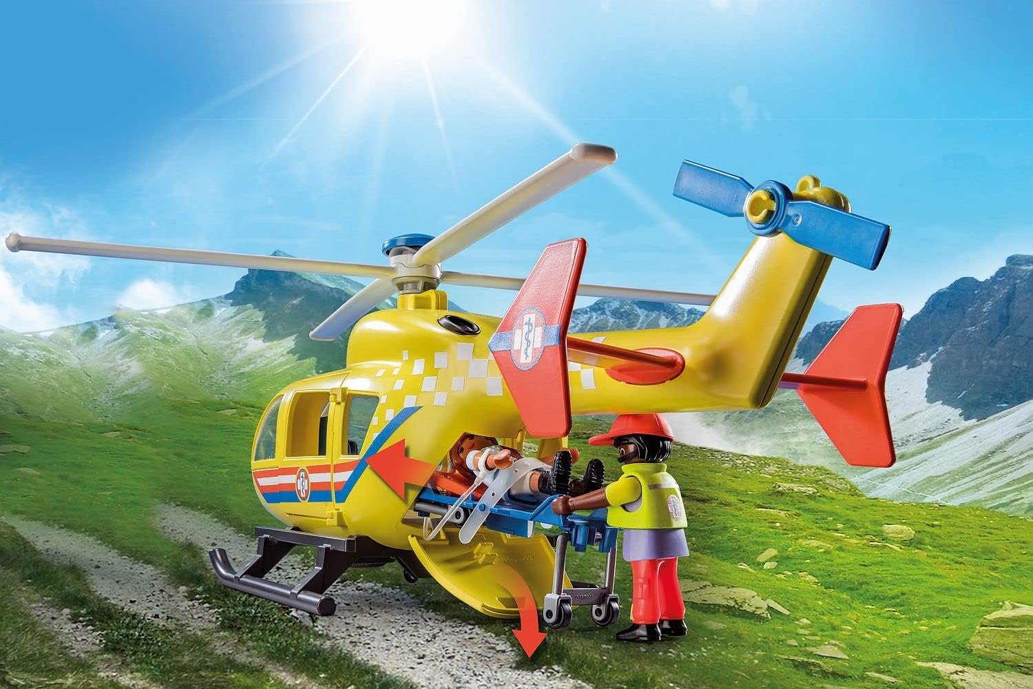 Żółty helikopter ratunkowy z noszami i dwiema postaciami w górskim krajobrazie.