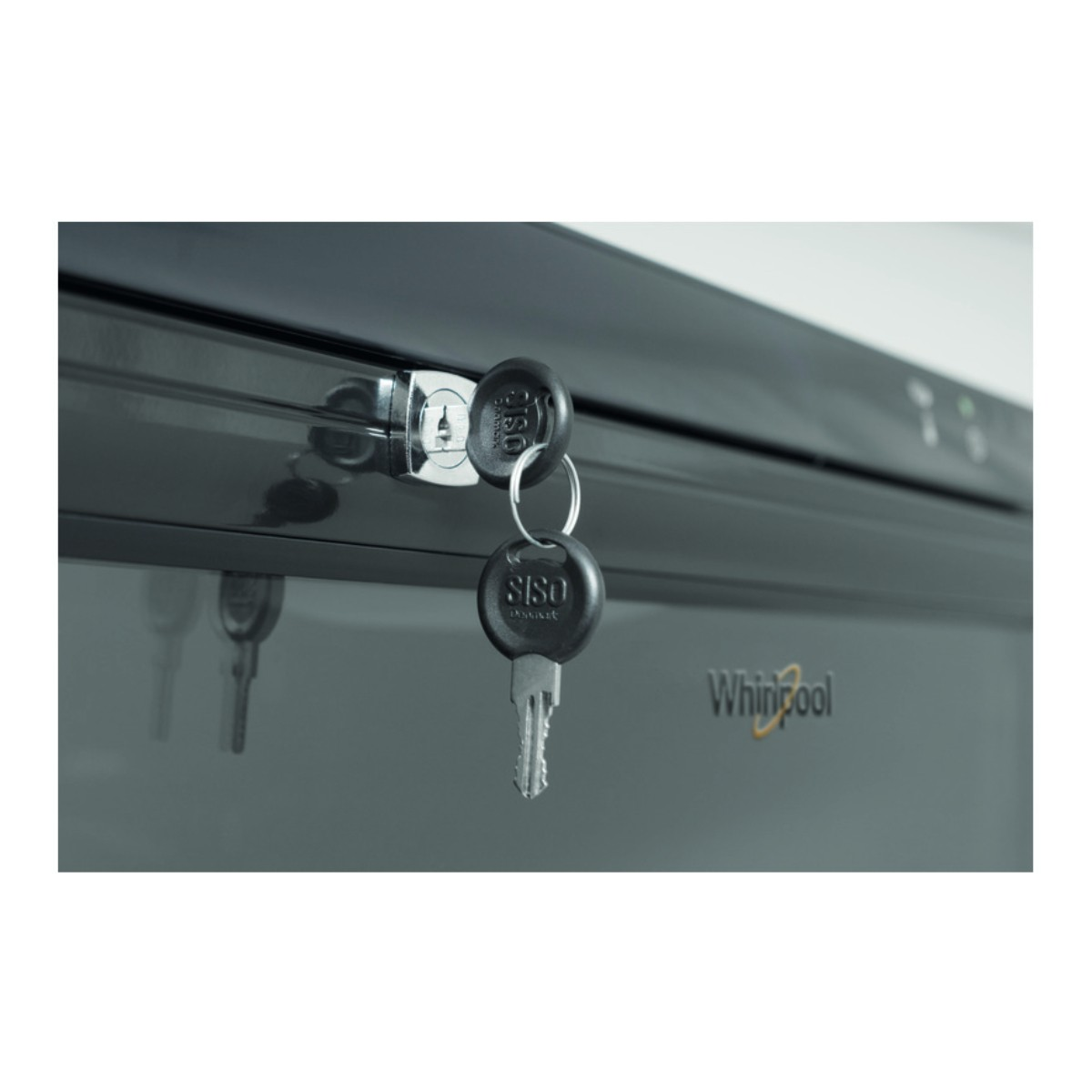 Due chiavi pendono da una serratura su un elettrodomestico Whirlpool grigio scuro.