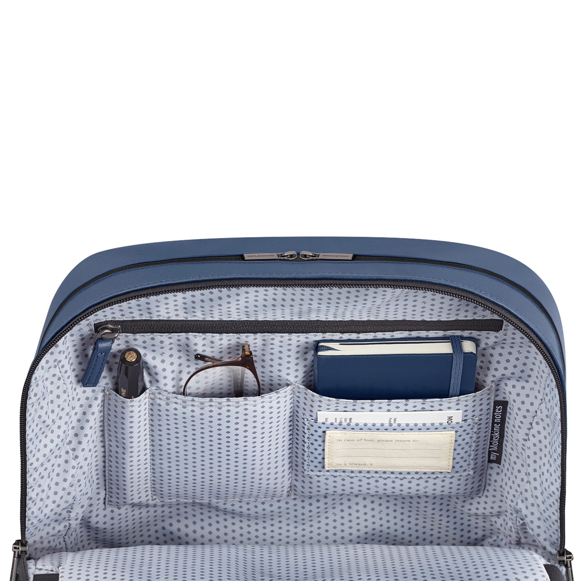 Interno di una borsa blu con tasche, penna, occhiali e taccuino.