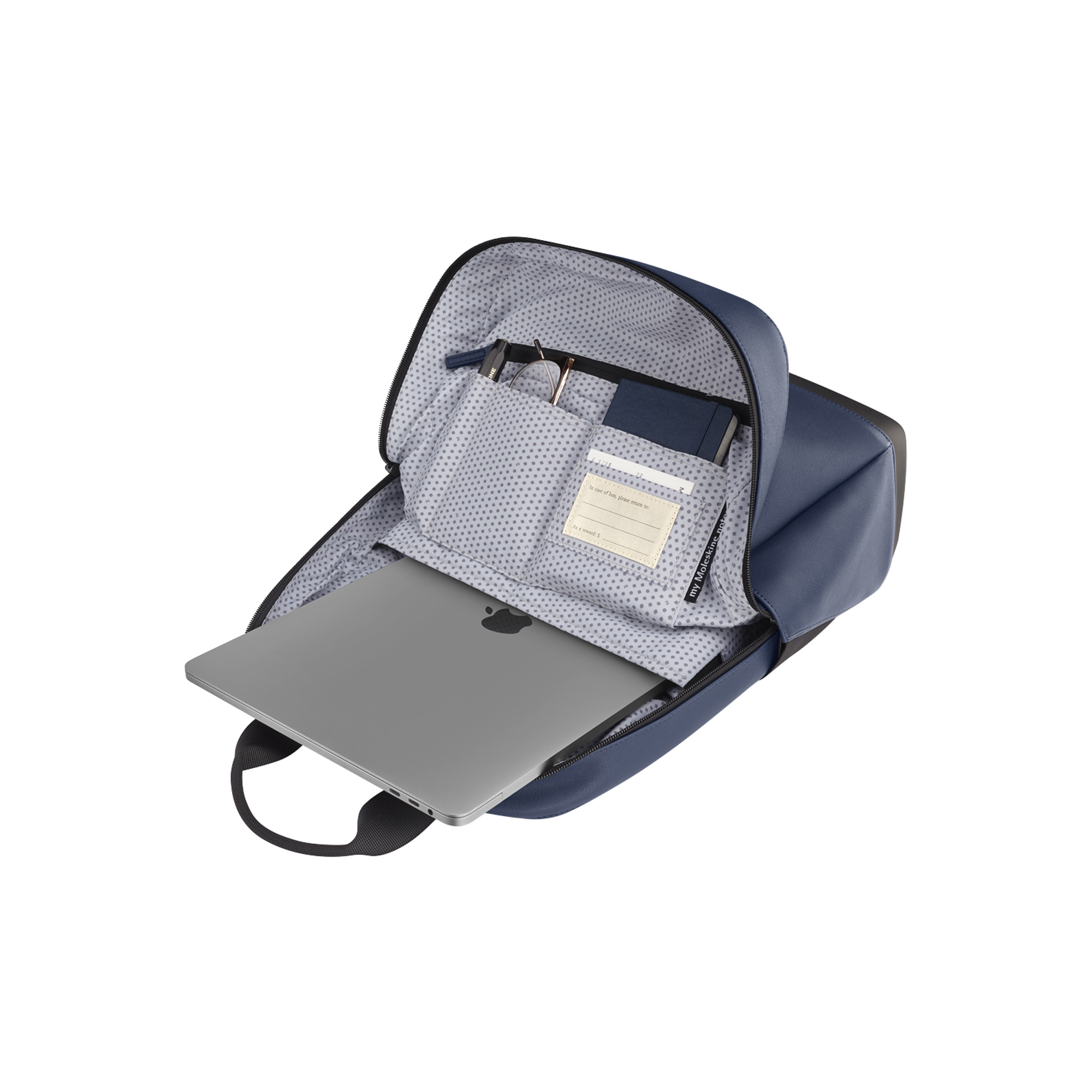Zaino blu scuro con scomparto aperto, laptop, occhiali e taccuino.