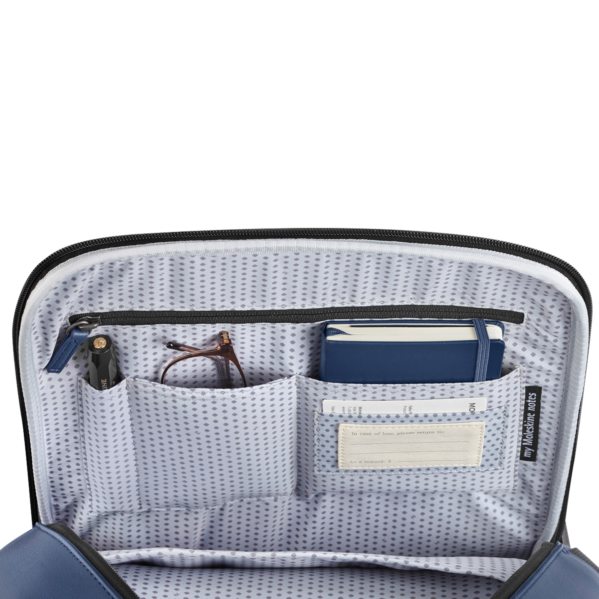 Interno di una borsa blu: penna, occhiali, taccuino blu e biglietto di ritorno.