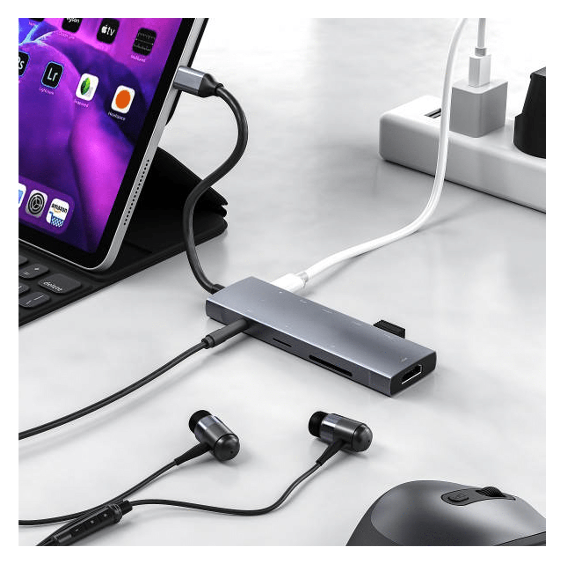 Een tablet met USB-C hub, koptelefoon en muis, aangesloten op een stopcontact.