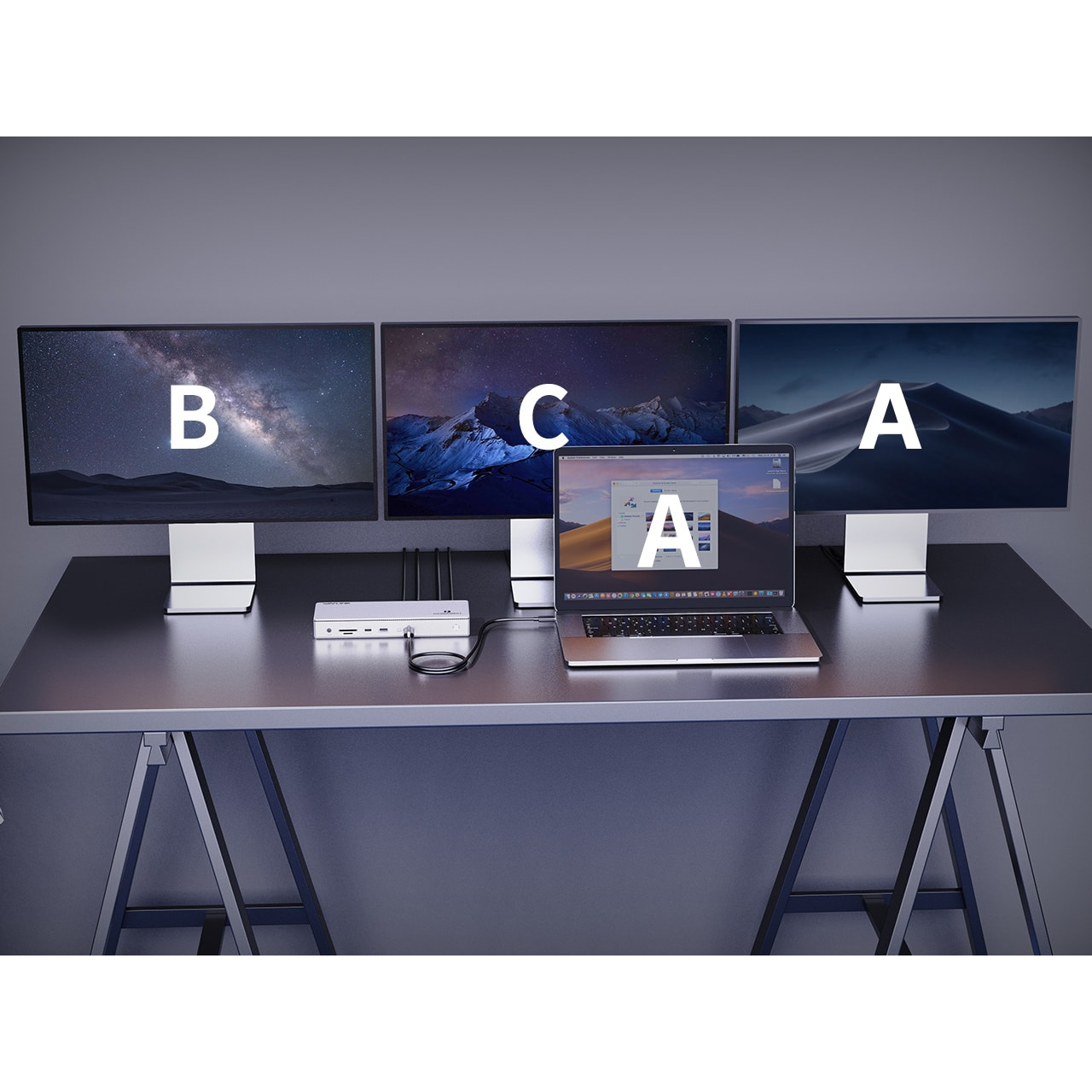 Een MacBook met drie externe monitoren, een docking station en kabels op een bureau.