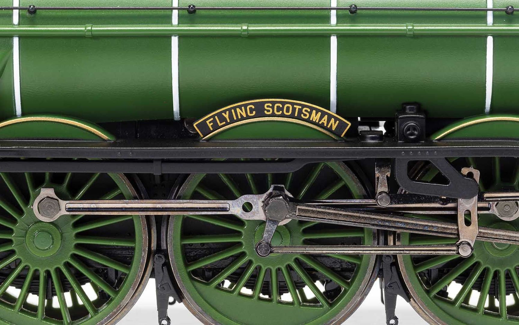 Zbliżenie zielonej lokomotywy modelarskiej z tabliczką "Flying Scotsman".