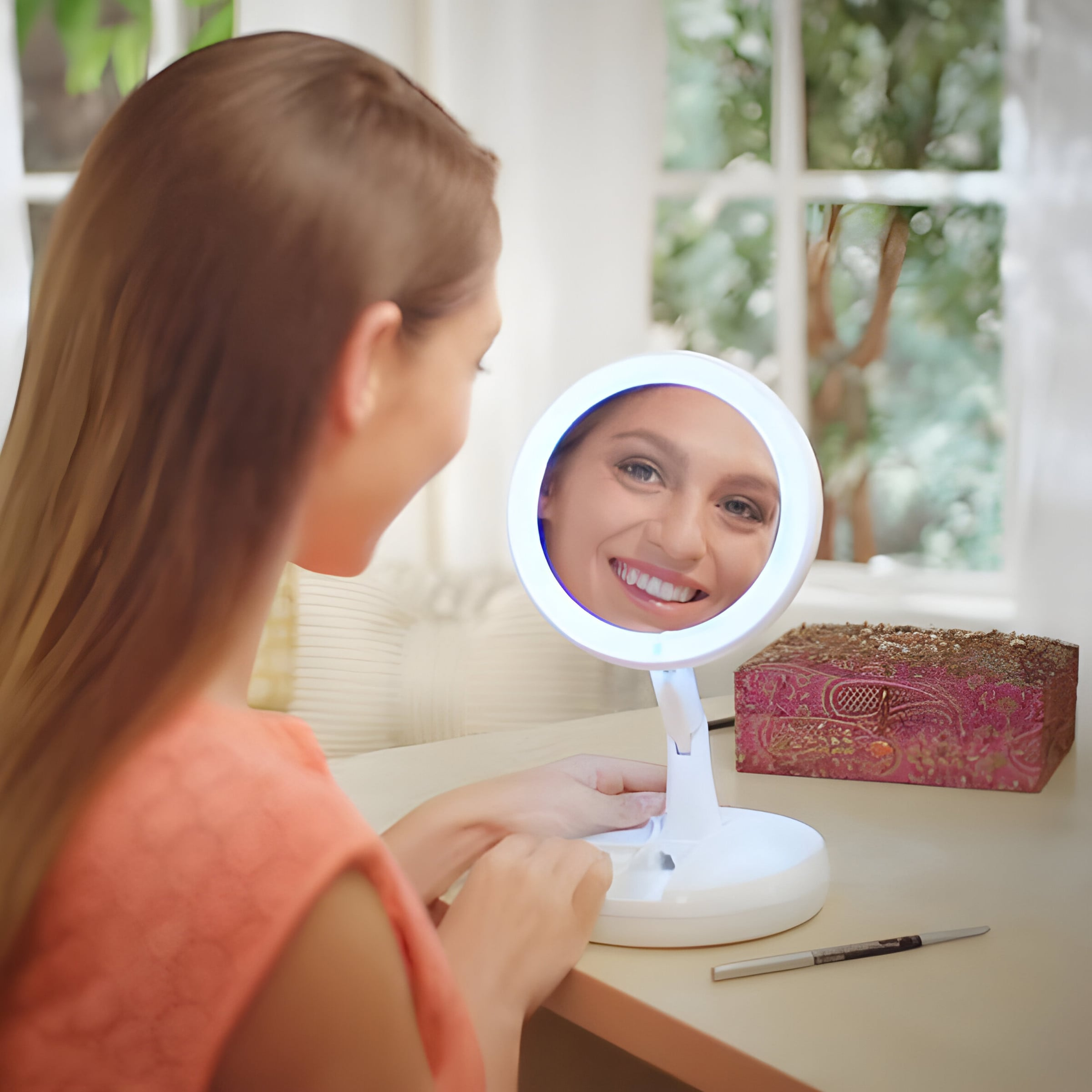 Una donna guarda in uno specchio per il trucco illuminato che mostra il suo viso.
