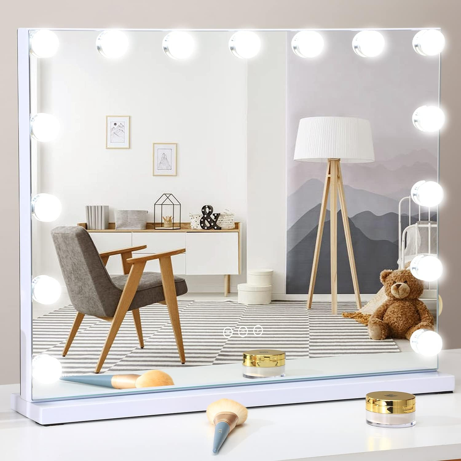 Uno specchio da toeletta illuminato riflette una stanza con sedia, lampada, orsacchiotto e decorazioni.