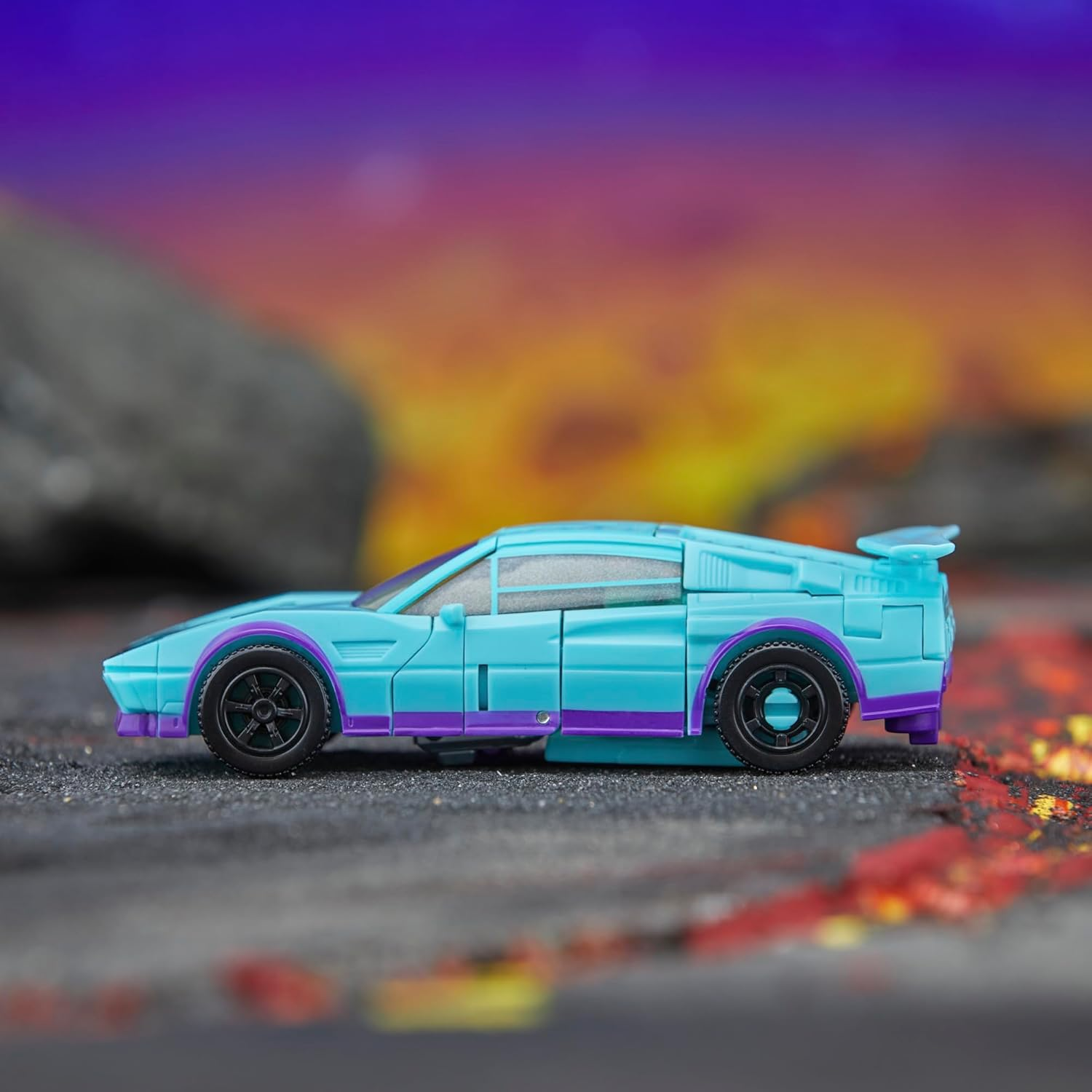 Ein hellblauer Sportwagen mit lila Akzenten steht auf grauem Untergrund.
