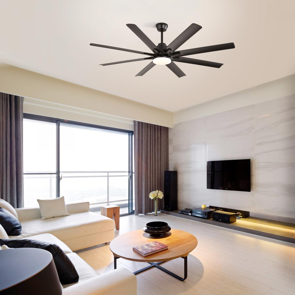 Ein dunkler Deckenventilator mit Beleuchtung über einem weißen Sofa, Couchtisch und Fernseher.