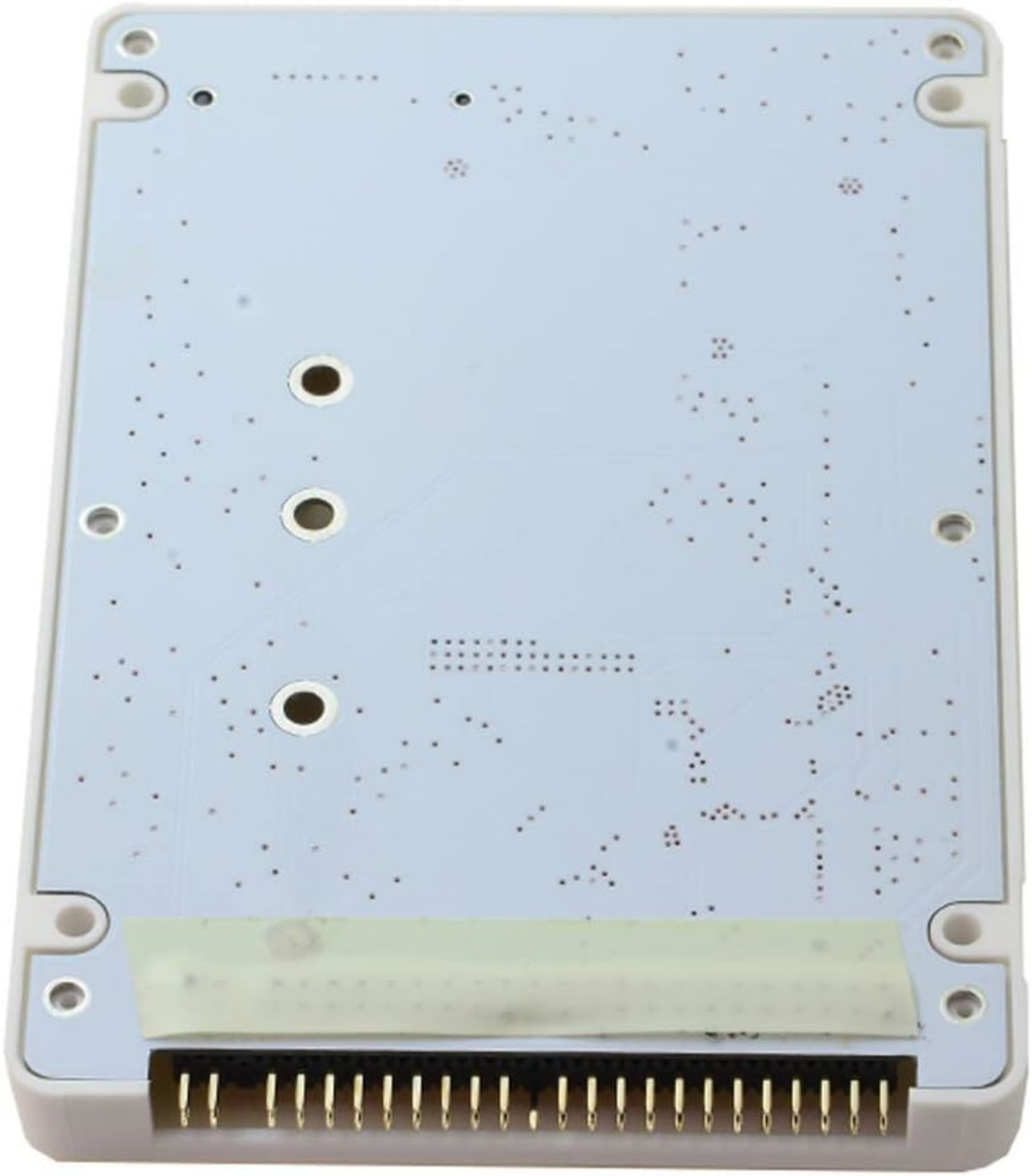 Rückseite einer weißen Platine mit vielen kleinen Punkten und drei runden Löchern. Steckverbinderstifte sichtbar.