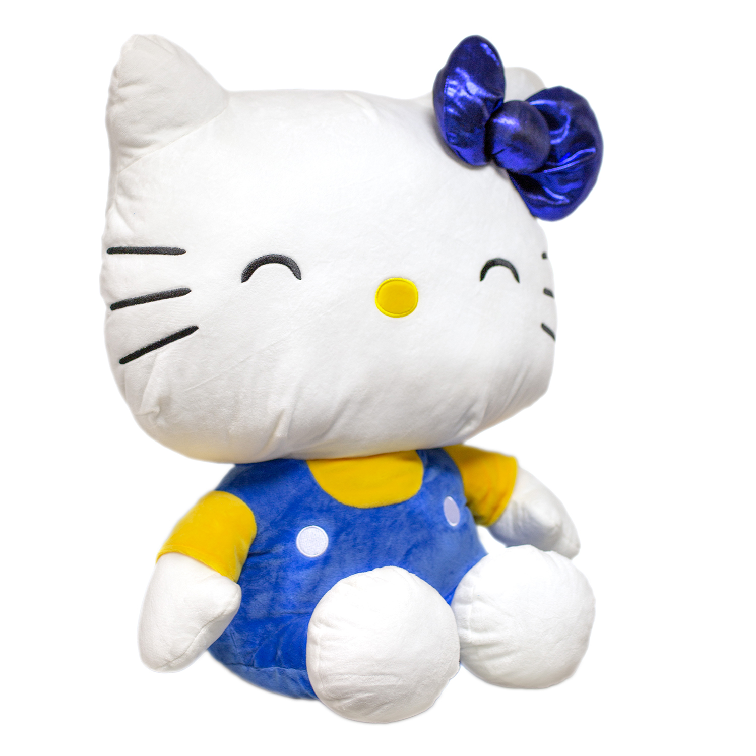 Ein weißer Hello Kitty Plüsch mit blauem Latzhose und gelbem Shirt.