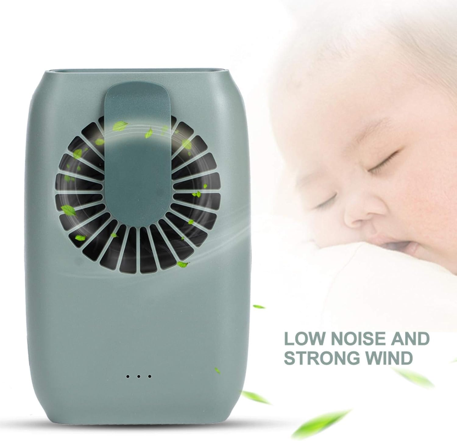 Ein kleiner, grüner Ventilator mit Blättern, die fliegen, neben einem schlafenden Baby.
