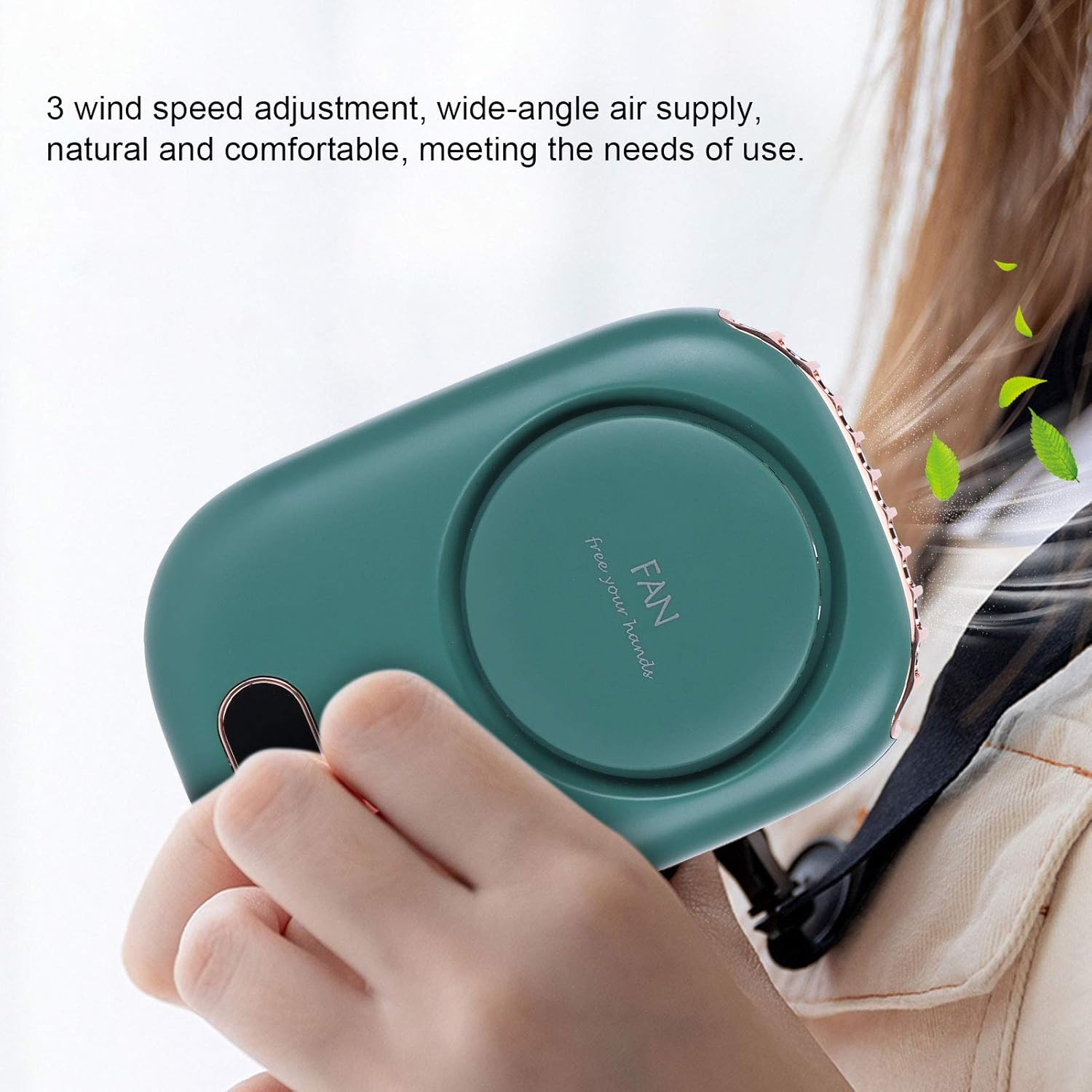 Eine grüne Nackenventilator-Einheit wird von einer Hand gehalten. Lüfterblatt ist sichtbar.