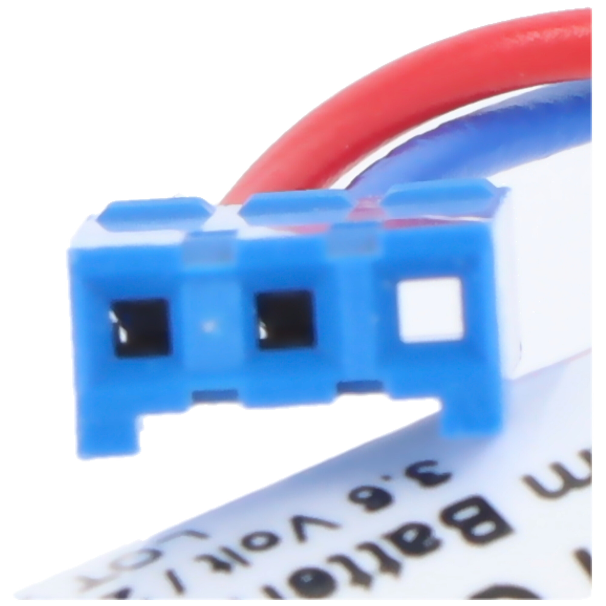 Blauer Stecker mit roten und blauen Kabeln über einer Batterie.