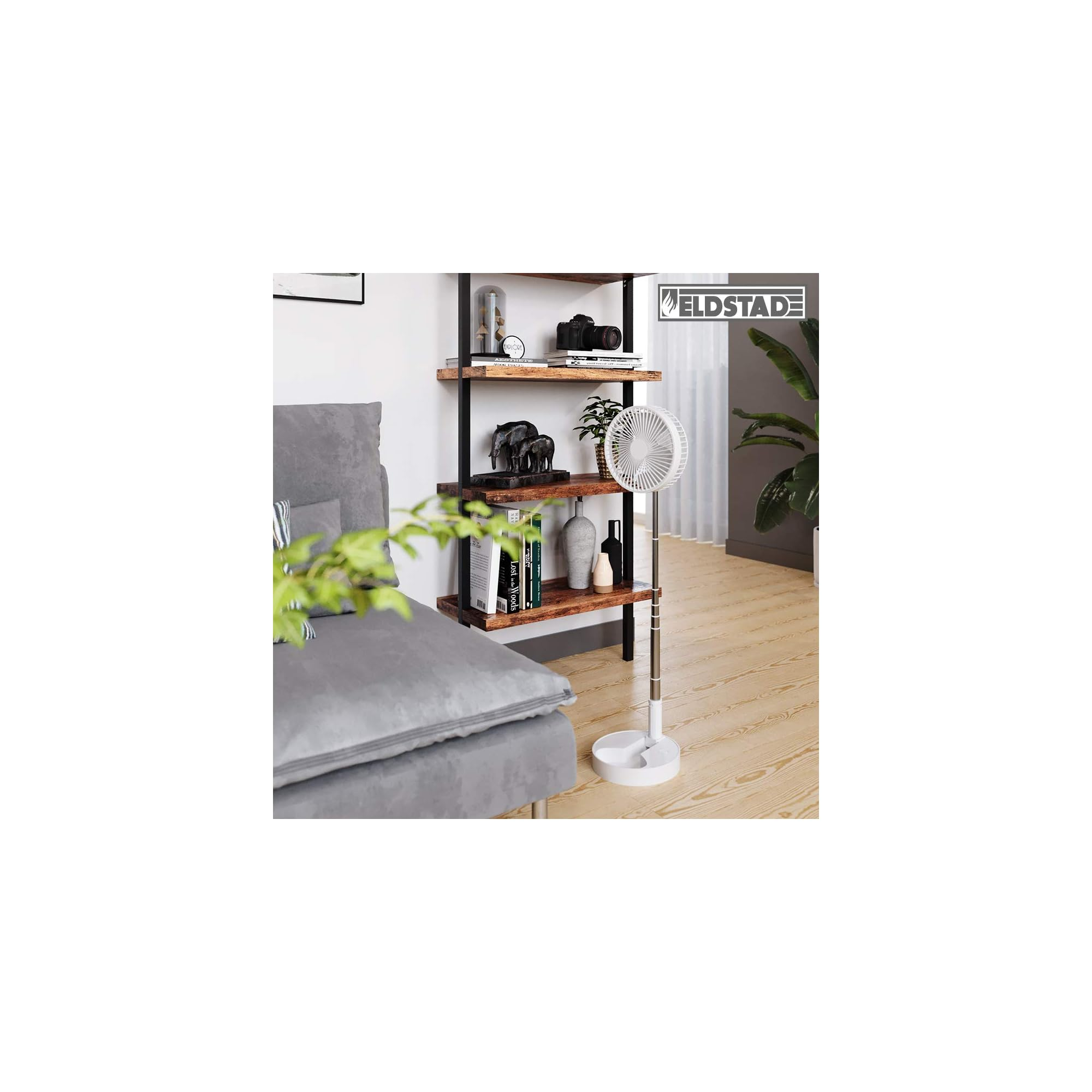 Ein weißer Standventilator steht neben einem Regal mit Büchern und Dekoration.