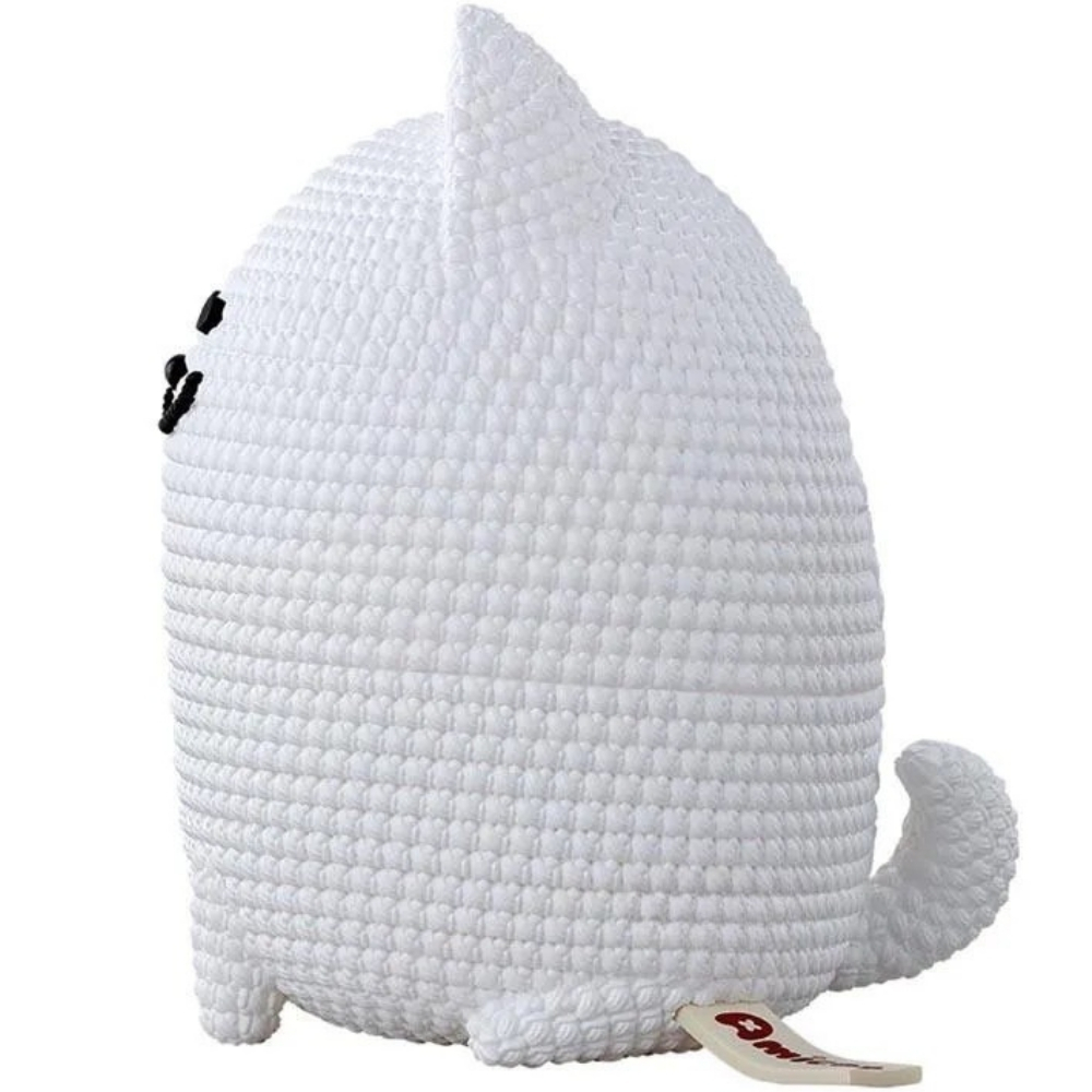 Gatto bianco all'uncinetto con occhi neri e coda. Spunta un'etichetta di legno.