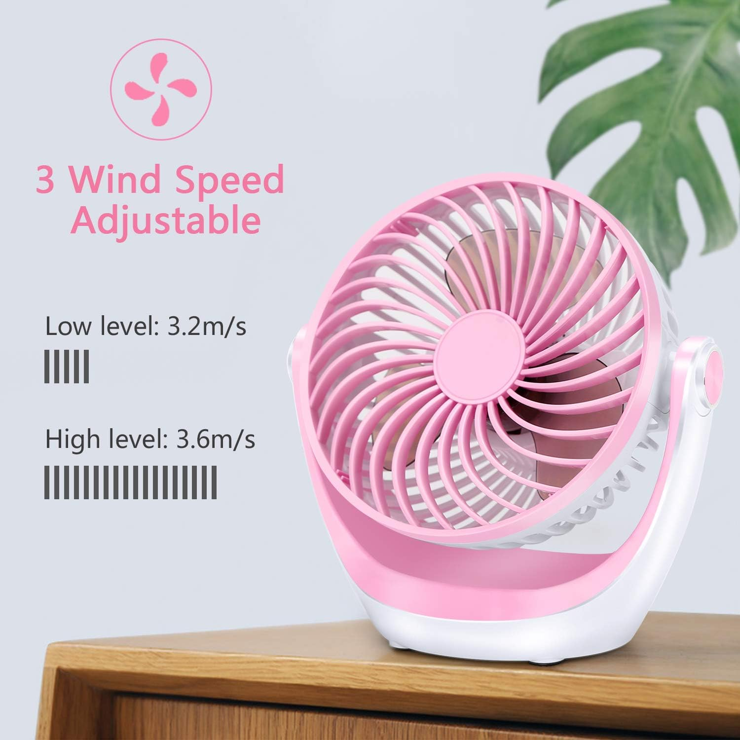 Ein rosafarbener Ventilator mit drei einstellbaren Geschwindigkeitsstufen steht auf einem Holzmöbel.