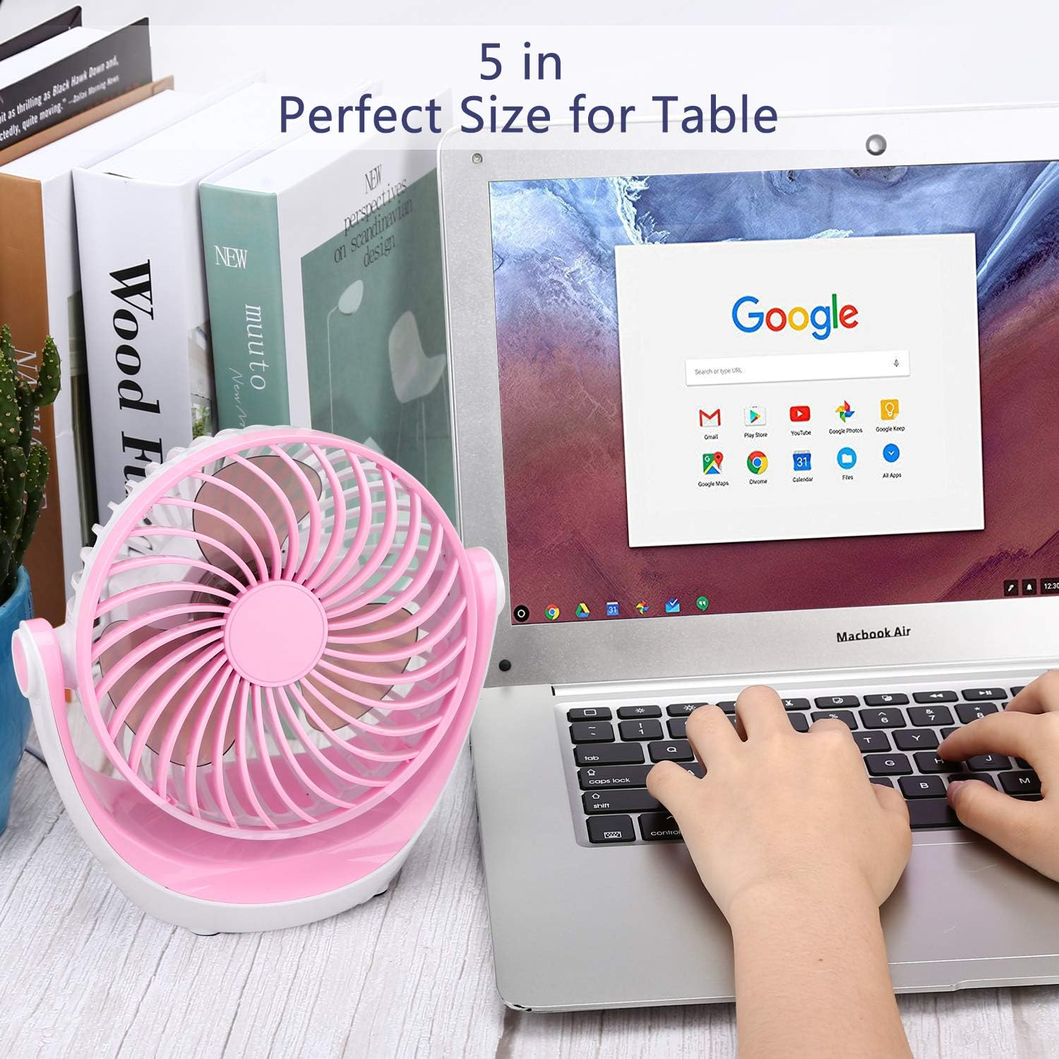 Ein pink-weißer Ventilator steht neben einem geöffneten Laptop, der die Google-Startseite anzeigt.