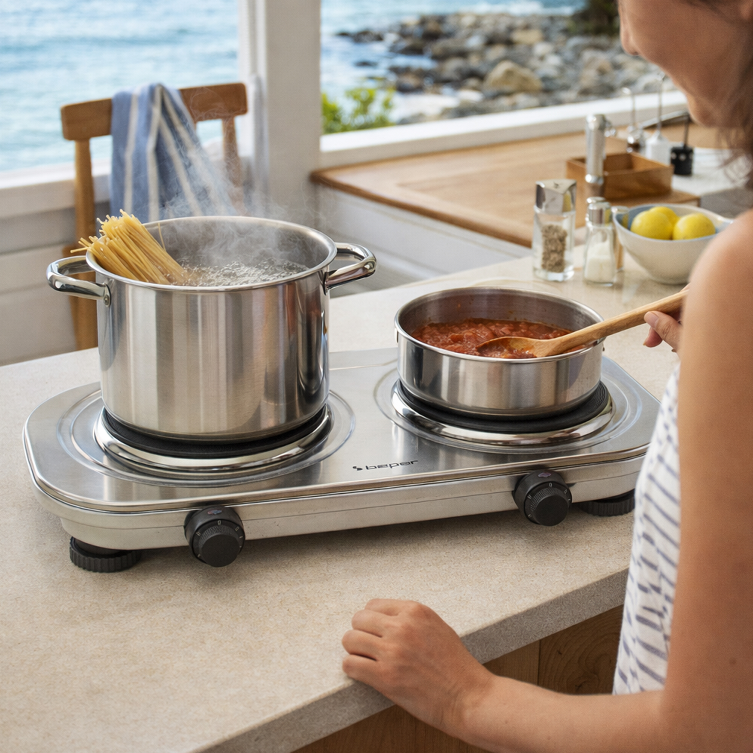 Una donna cucina spaghetti e sugo in una cucina sul mare.