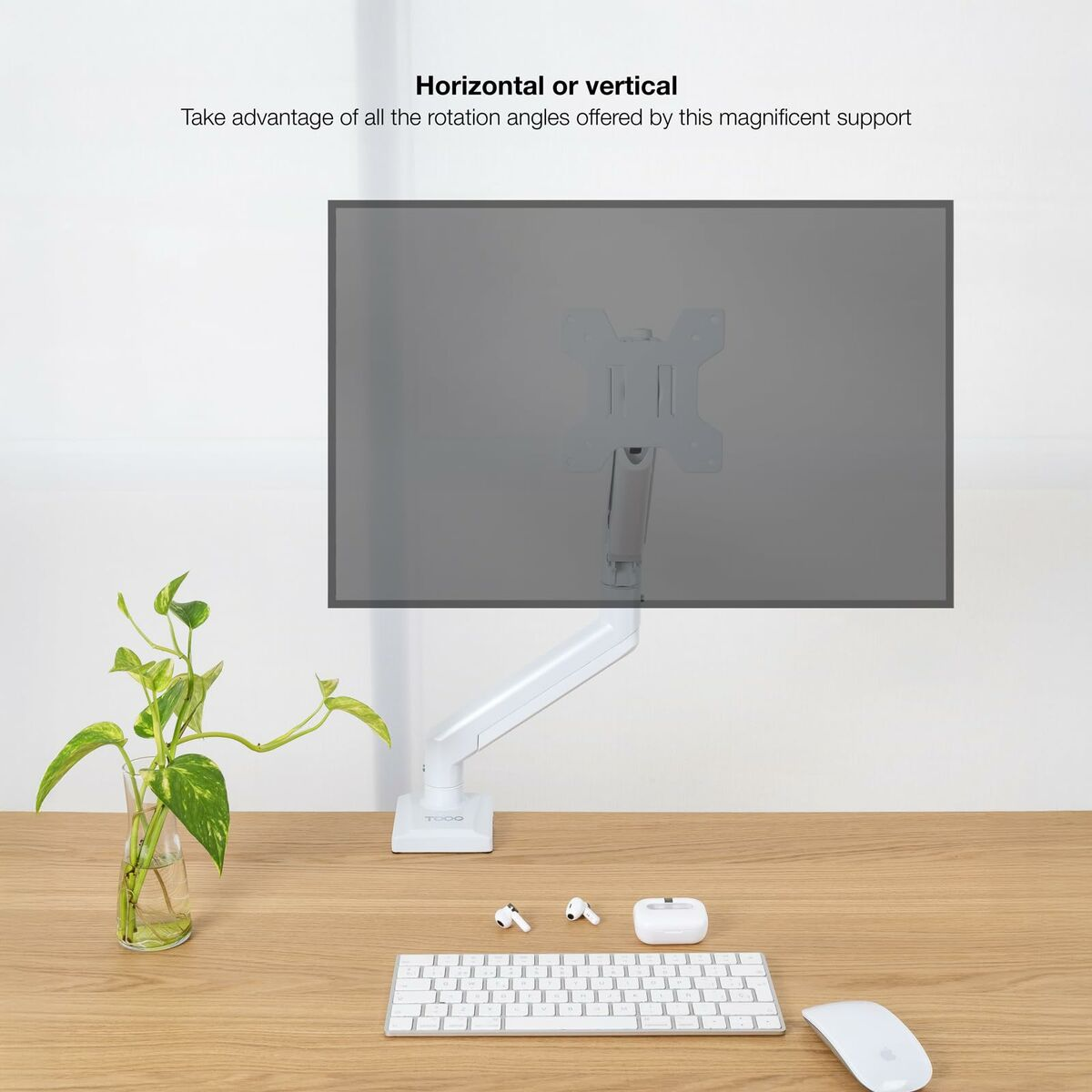 Ein weißer Monitorarm hält einen grauen Monitor über einem Schreibtisch mit Tastatur, Maus, Pflanze und Ohrhörern.