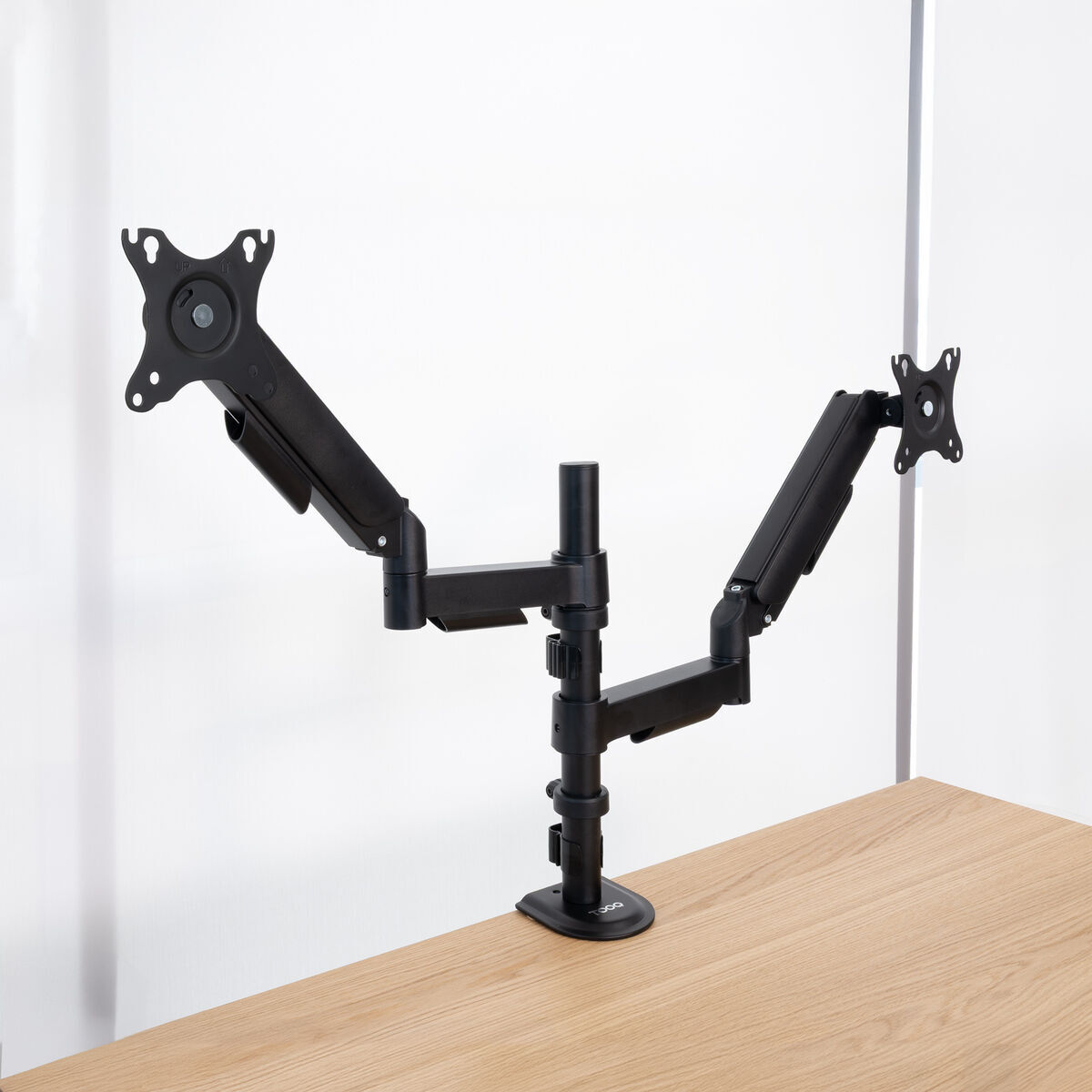 Ein schwarzer Doppelmonitor-Ständer auf einem Holztisch.