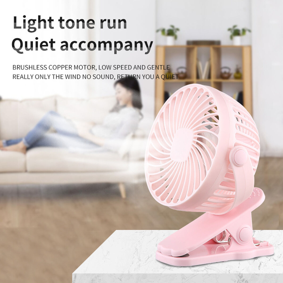 Pinker Clip-Ventilator auf Marmoroberfläche mit verschwommenem Hintergrund einer Person auf einer Couch.
