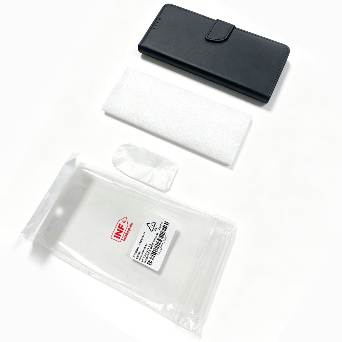 Eine schwarze Handyhülle, weißer Schaumstoff und eine klare Plastiktüte mit Tuch.