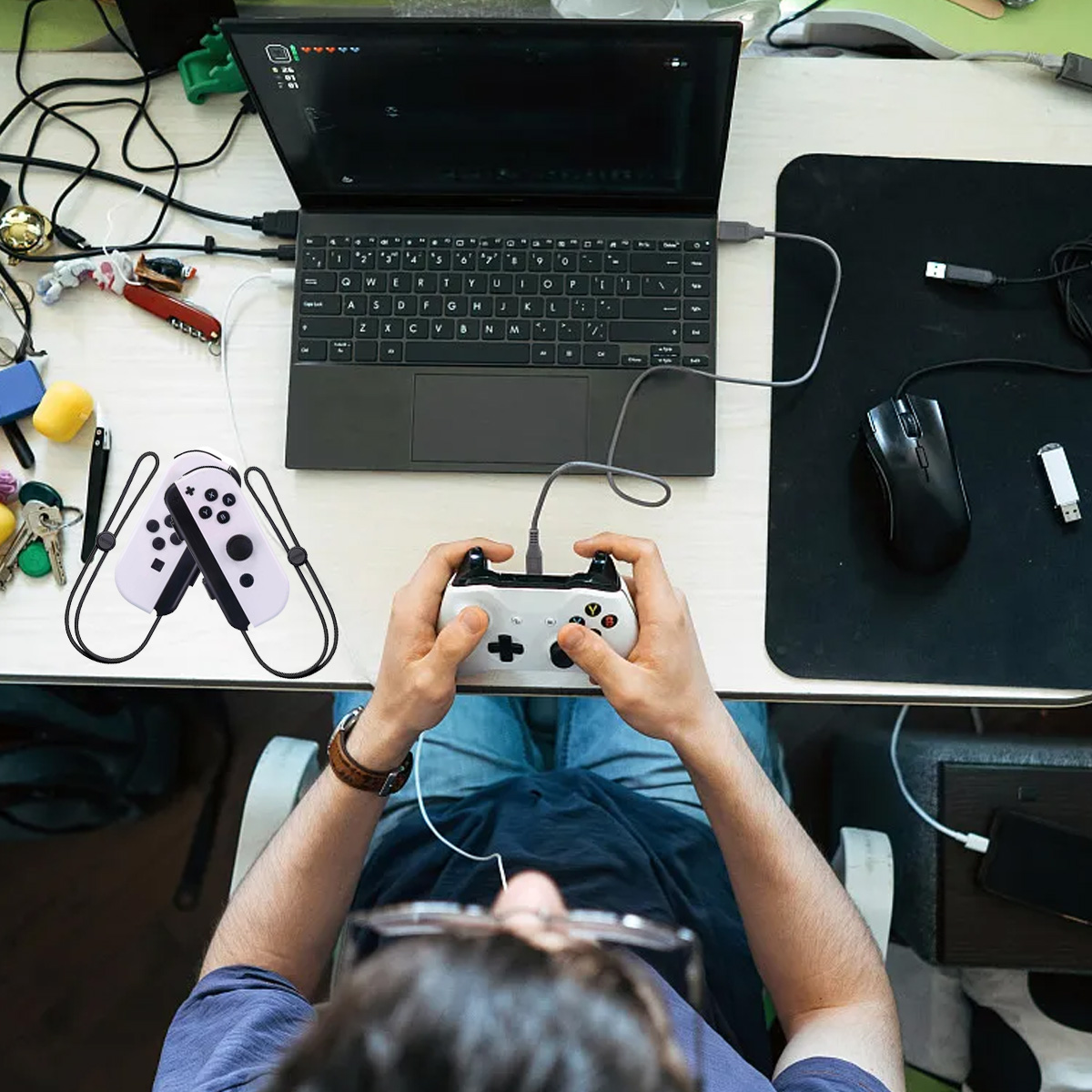 Person spielt Videospiele mit einem Controller, der an einen Laptop angeschlossen ist.