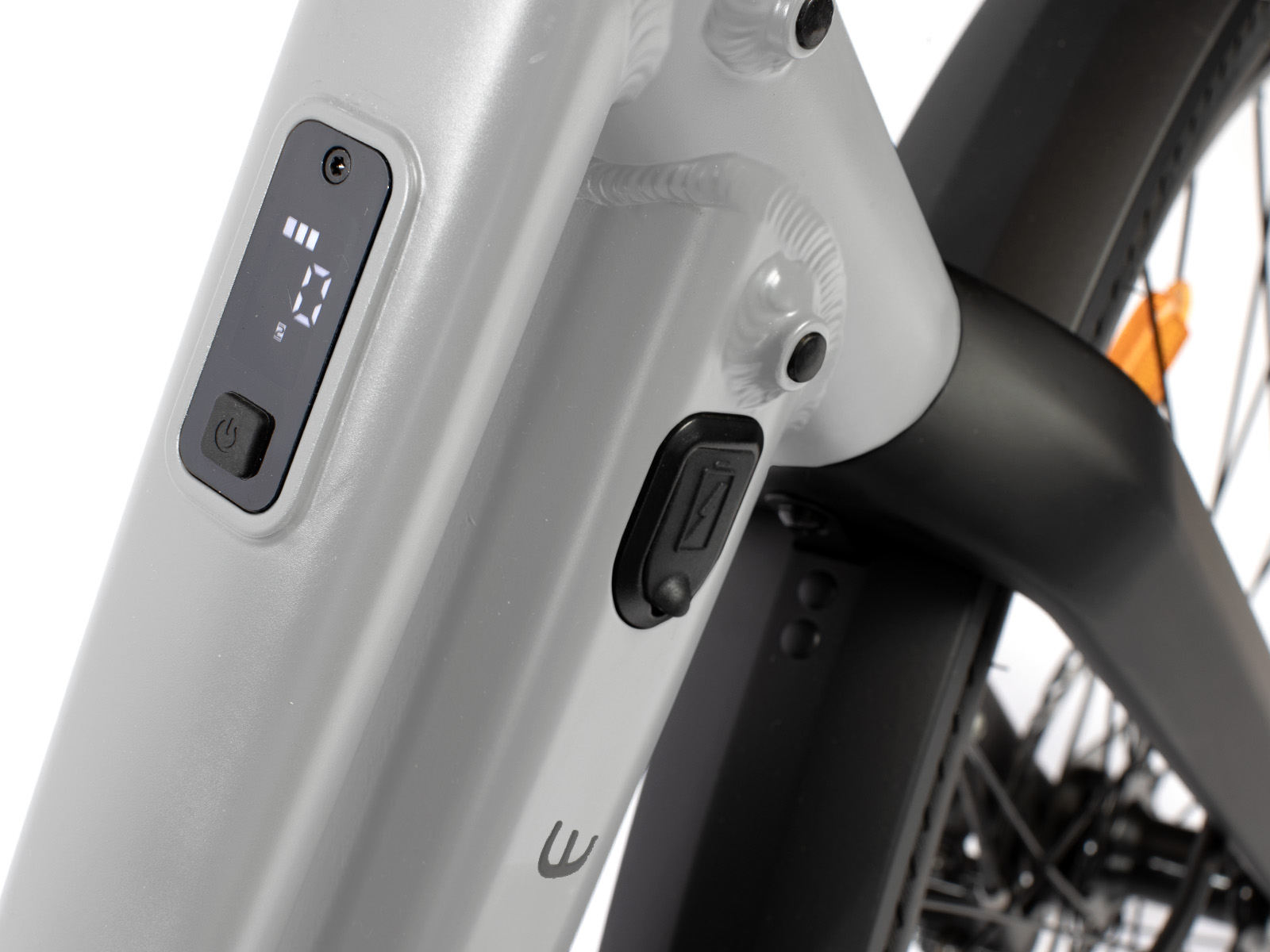Nahaufnahme einer grauen E-Bike-Rahmenanzeige mit Ladeanschluss und Rücklicht.