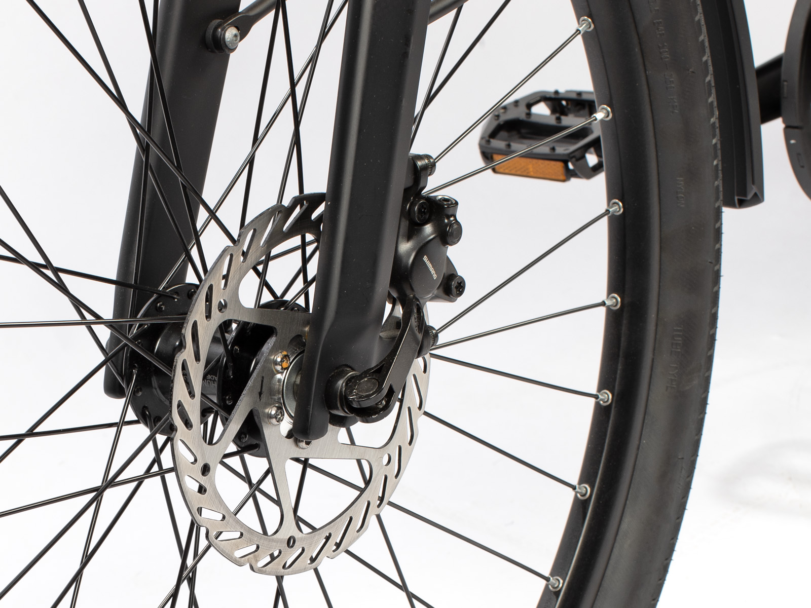 Nahaufnahme eines Fahrradrads mit Scheibenbremse und Pedal.
