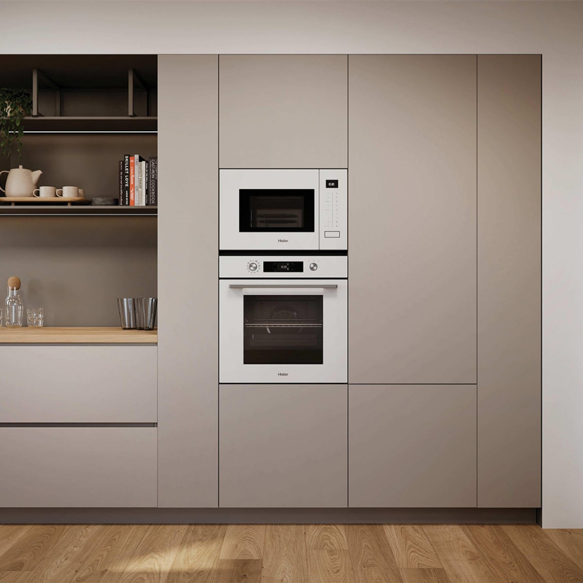 Cocina moderna con horno y microondas blancos empotrados. Estantes abiertos con libros y tetera.